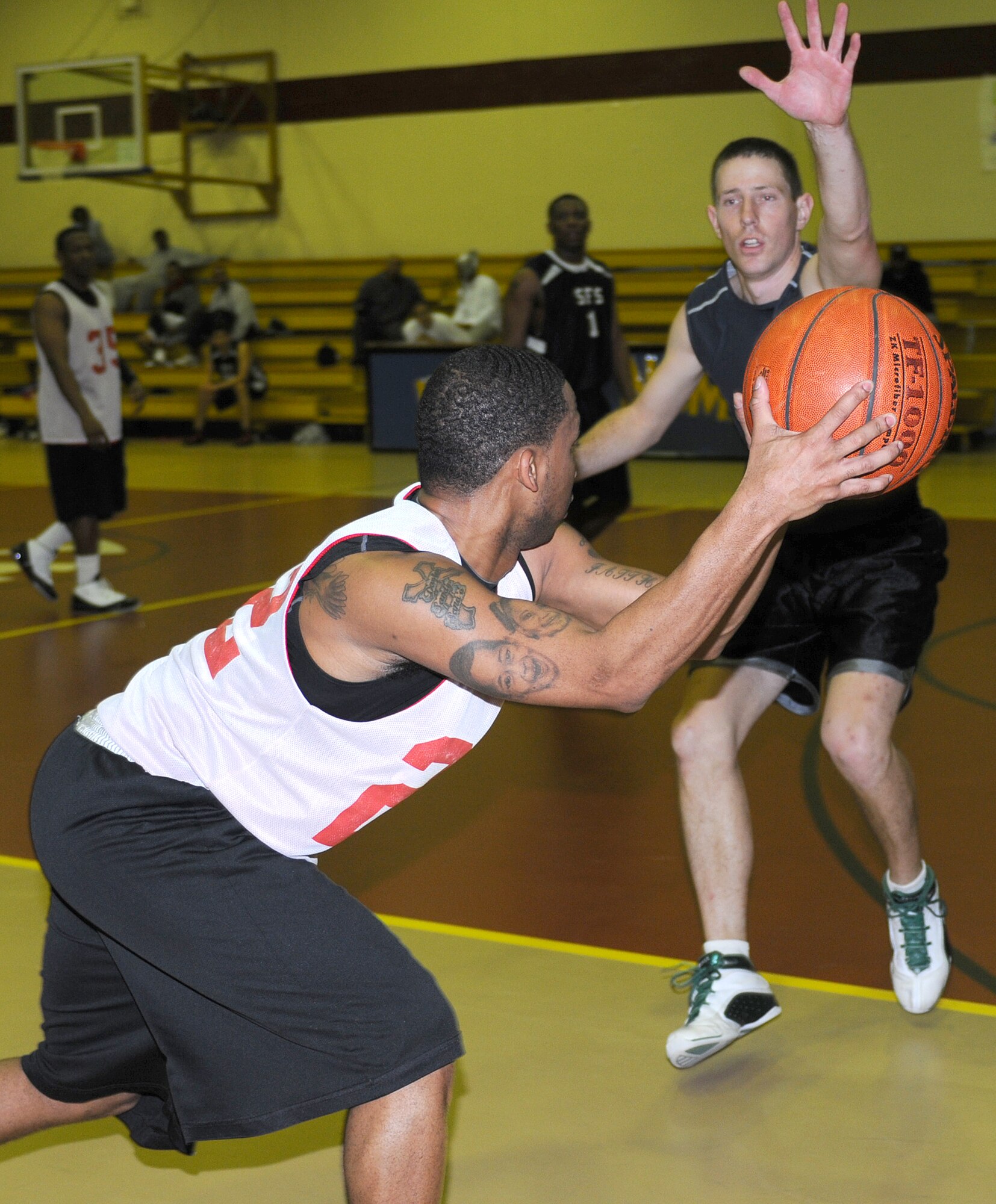 Staff Sgt. Maurice Walker, 39th Logistics Readiness Squadron, attempts to pass a basketball to a team member while Staff Sgt. Ryan Schrader, rushes the ball during an intramural basketball game Monday, Feb. 22 at Incirlik Air Base, Turkey. The 39th SFS team squeaked by the 39th LRS team 54-53 in the championship game Feb. 23. (U.S. Air Force photo/Senior Airman Alex Martinez)
