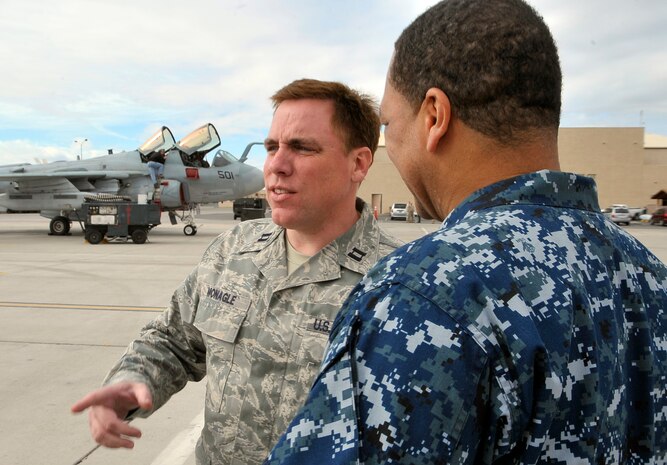 NELLIS AIR FORCE BASE, Nev. -- Red Flag Chaplain (Capt.) Robert "Father Bob" Monagle talks with Petty Officer 1st Class Robert Porter, an aviation machinist from Naval Air Station Whidbey Island, Wash., during a break from maintenance on an EA-6B Prowler at Red Flag 10-3 Feb. 24. Chaplain Monagle is deployed to Red Flag from Holloman AFB, N.M., and is here to monitor morale and lend a friendly ear to anyone who needs to talk. (U.S. Air Force photo illustration by Tech. Sgt. Chris Flahive)