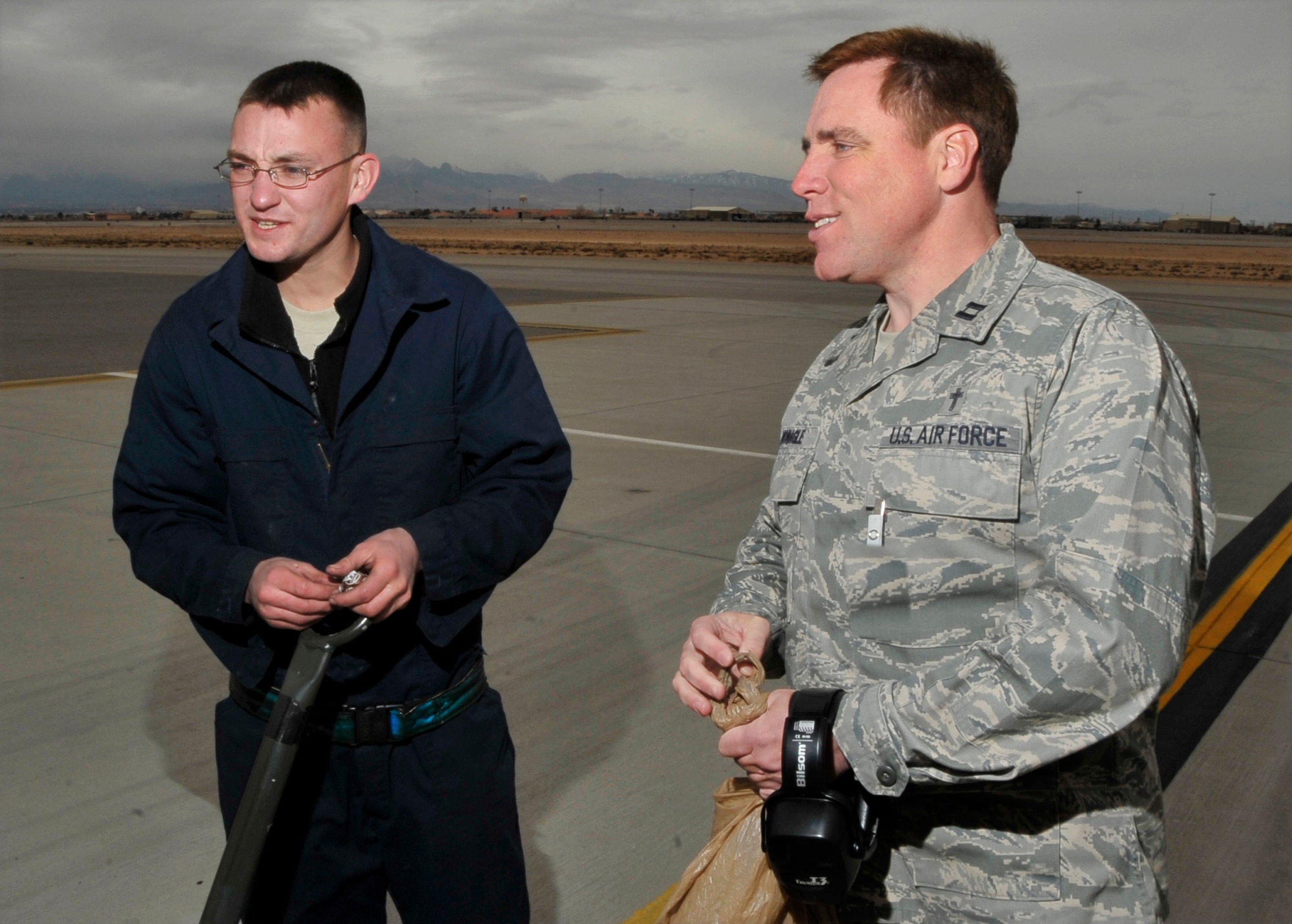 NELLIS AIR FORCE BASE, Nev. -- Red Flag Chaplain (Capt.) Robert "Father Bob" Monagle talks with Senior Airman Jonathan Yarbrough, a crew chief with the 7th Aircraft Maintenance Squadron, Dyess AFB, Texas, before pilots on a B-1B Lancer start engines at Red Flag 10-3 Feb. 24. Chaplain Monagle is deployed to Red Flag from Holloman AFB, N.M., and is here to monitor morale and lend a friendly ear to anyone who needs to talk. (U.S. Air Force photo illustration by Tech. Sgt. Chris Flahive)