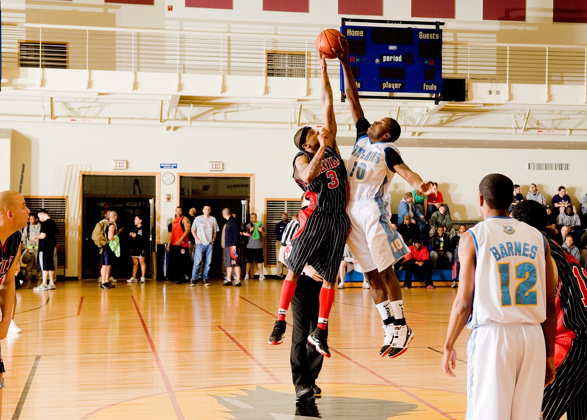 KUNSAN AIR BASE, Republic of Korea -- Tyric Gaddy, 8th Civil Engineer Squadron  and Jared Crowley, 8th Security Forces Squadron, go for the ball at the tip off of the intramural basketball championship game Feb. 24.  The 8 CES, in a tight clash beat the 8 SFS,  52 - 50. (U.S. Air Force photo/Senior Airman Jonathan Steffen)  

