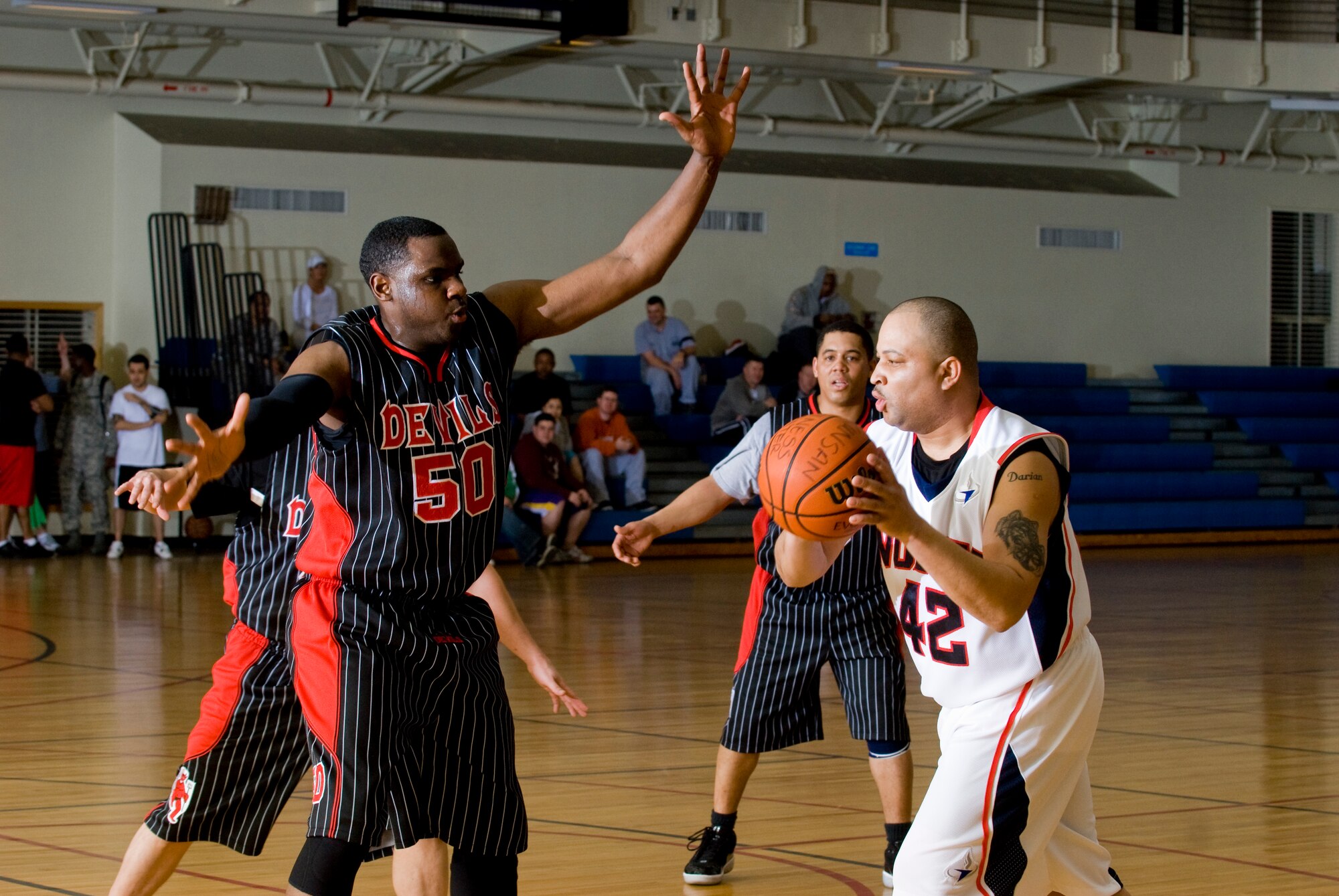 KUNSAN AIR BASE, Republic of Korea -- LaDale Evans, 8th Force Support Squadron, looks for someone to pass too while Claborne Staten, 8th Civil Engineer Squadron, tries to block him during the over 30 basketball championship Feb. 24.  The 8 FSS pulled through for the win against the 8 CES 51 to 43. (U.S. Air Force photo/Senior Airman Jonathan Steffen)  

