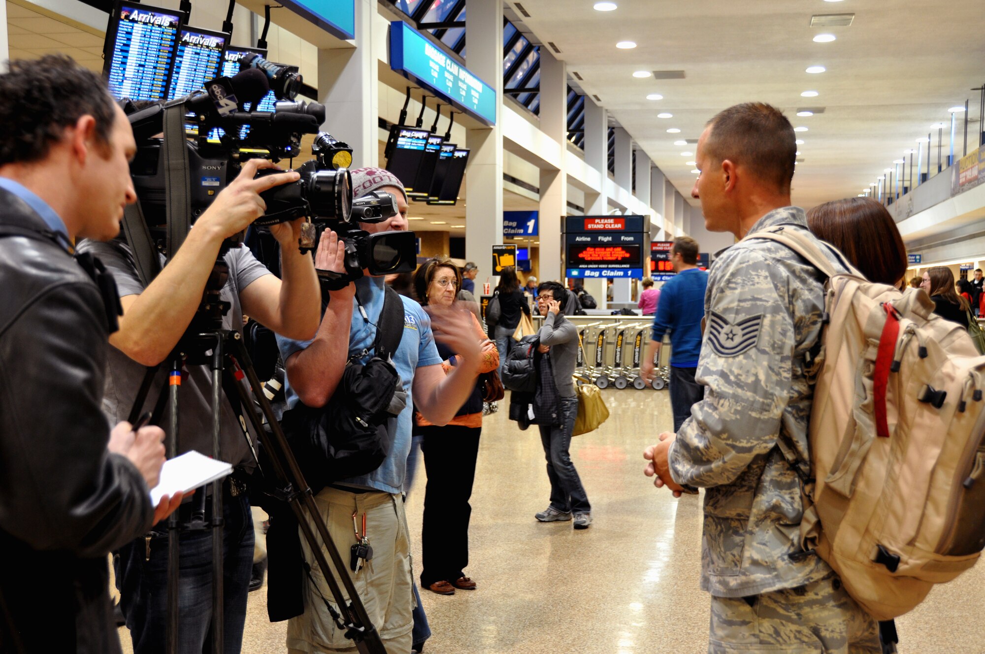 Local news media line up to interview Tech. Sgt. Justin Adams, 67th Aerial Port Squadron, in the baggage claim area of the Salt Lake City International Airport after he and four others arrived home following a month-long deployment Haiti. The Citizen Airmen restored airfield operations at Port-au-Prince’s airport following the catastrophic earthquake that hit the island country Jan. 12. 