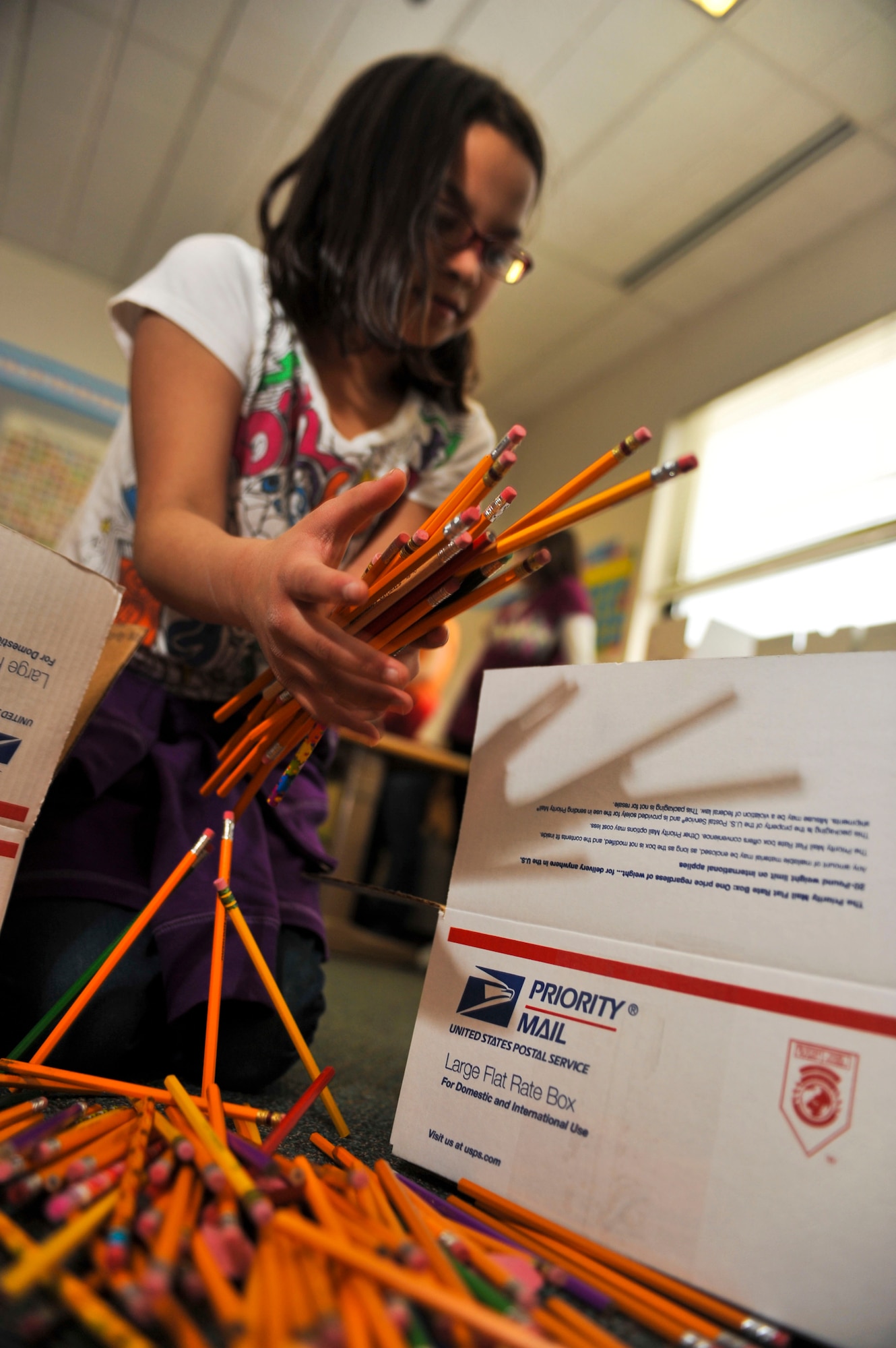 ELMENDORF AIR FORCE BASE, Alaska – Mikaelyn Gogue, a fourth grade Aurora Elementary School student, loads pencils into a box, Feb. 25, which will be sent to students in Konar River Valley, Afghanistan. During the past several weeks, students from AES’s Student Council and Service Learning Club held a school supply drive, collecting pens, pencils, spiral notebooks, colored pencils, notebook paper, markers and hand-operated pencil sharpeners that will be distributed throughout 13 schools in the Konar River Valley. (Air Force photo by Airman 1st Class Christopher Gross) 
