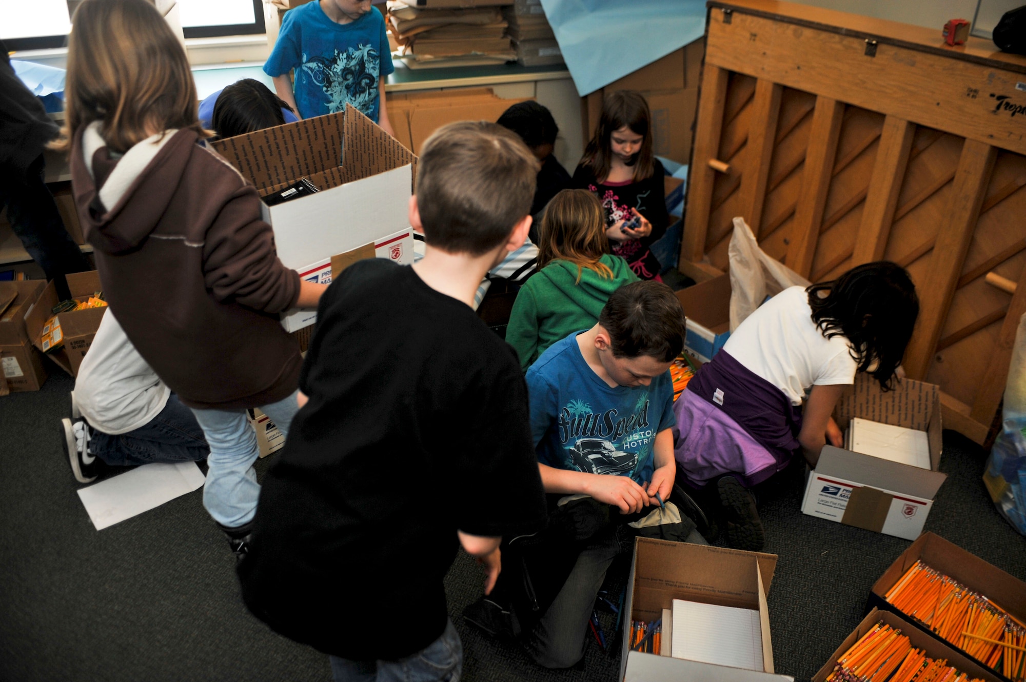 ELMENDORF AIR FORCE BASE, Alaska – Students from Aurora Elementary School work together to sort school supplies and pack them into boxes, Feb. 25, which will then be sent to students in Konar River Valley, Afghanistan. During the past several weeks, students from AES’s Student Council and Service Learning Club held a school supply drive, collecting pens, pencils, spiral notebooks, colored pencils, notebook paper, markers and hand-operated pencil sharpeners that will be distributed throughout 13 schools in the Konar River Valley. (Air Force photo by Airman 1st Class Christopher Gross) 