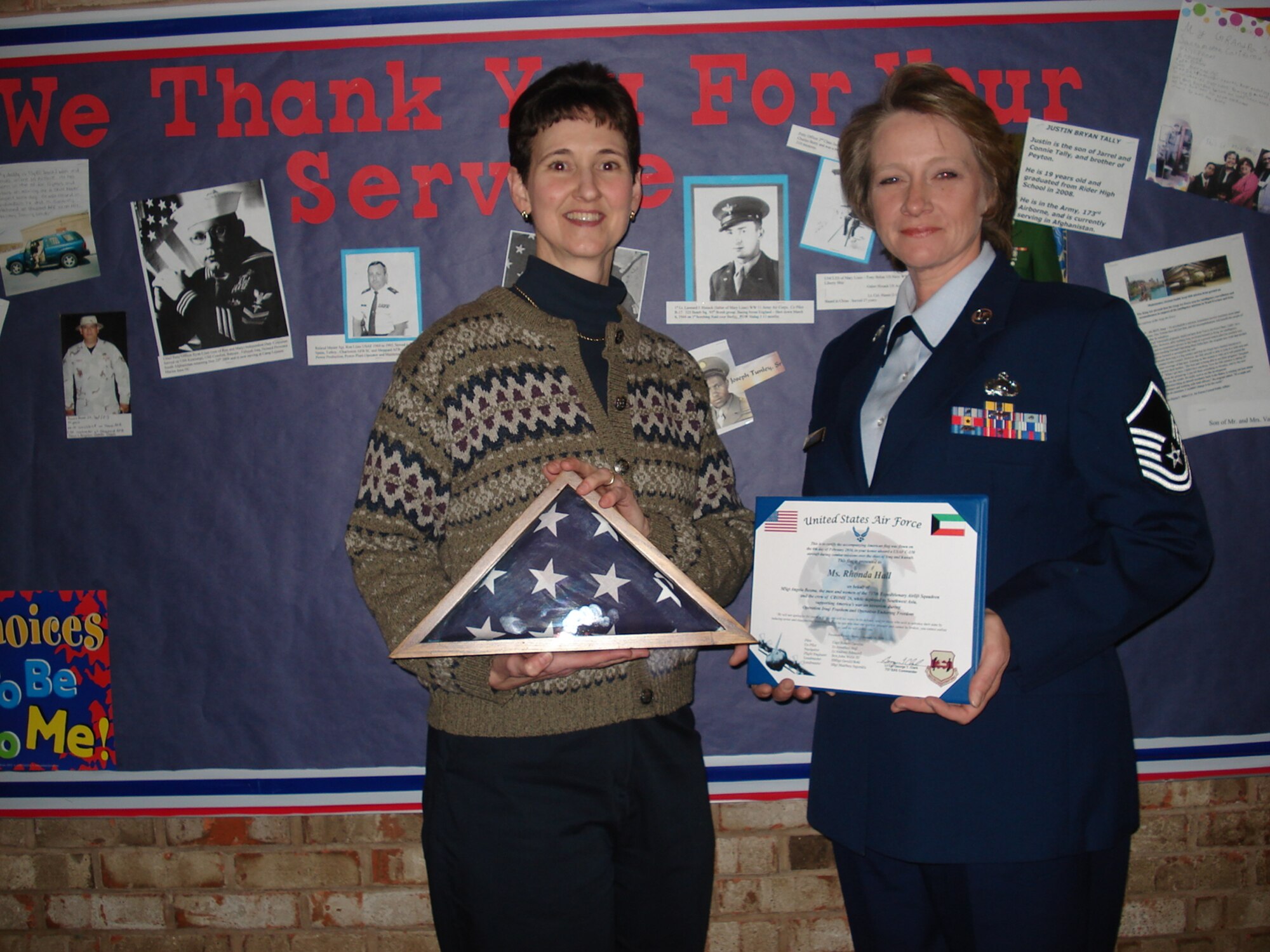 Master Sgt. Angela Bosma (right), 82nd Force Support Squadron NCO in charge of customer support, presents an American flag to Ronda Hall, Haynes Northwest Academy Elementary School principal, 25 Feb.  During Master Sgt. Bosma's recent deployment to an undisclosed location in Southwest Asia, the flag was flown in Ms. Hall's honor.
 

Ms. Hall recruited the entire Kindergarten through sixth grade students to make hand-crafted Christmas decorations for the deployed members of the 387th Air Expeditionary Group in Southwest Asia.  She also worked to ensure its successful delivery.  (U.S. Air Force courtesy photo)