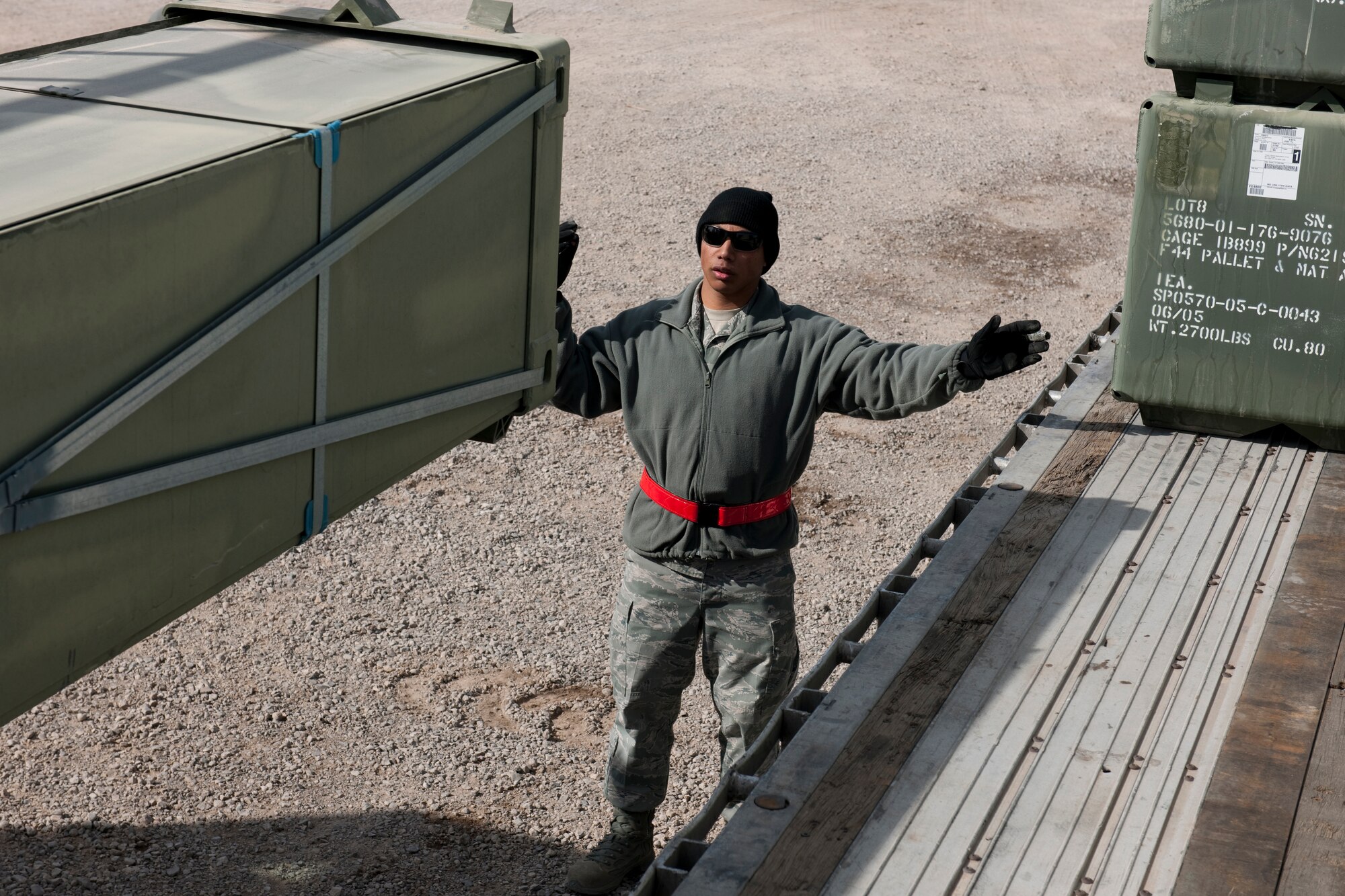 HOLLOMAN, AIR FORCE BASE, N.M. -- Airman 1st Class Teddy Perez, 49th Materiel Maintenance Support Squadron, ground guides a 13,000 pound loader carrying nearly 11,000 pounds of AM-2 matting onto a flatbed trailer on Feb. 24.  The 49th MMSS is deploying 480,000 square-feet of the matting that will be assembled to create airstrips supporting joint and coalition forces throughout Afghanistan. (U.S. Air Force photo by Staff Sgt. Joe Laws) (Released)