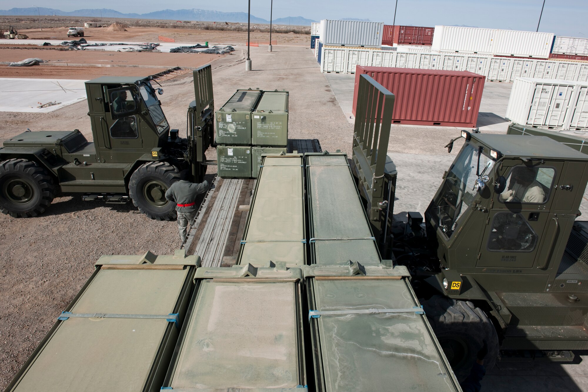 HOLLOMAN, AIR FORCE BASE, N.M. -- Airmen with the 49th Materiel Maintenance Support Squadron load AM-2 matting onto a flatbed trailer on Feb. 24th.  The 49th MMSS is deploying 480,000 square-feet of the matting that will be assembled to create airstrips supporting joint and coalition forces throughout Afghanistan. (U.S. Air Force photo by Staff Sgt. Joe Laws) (Released)