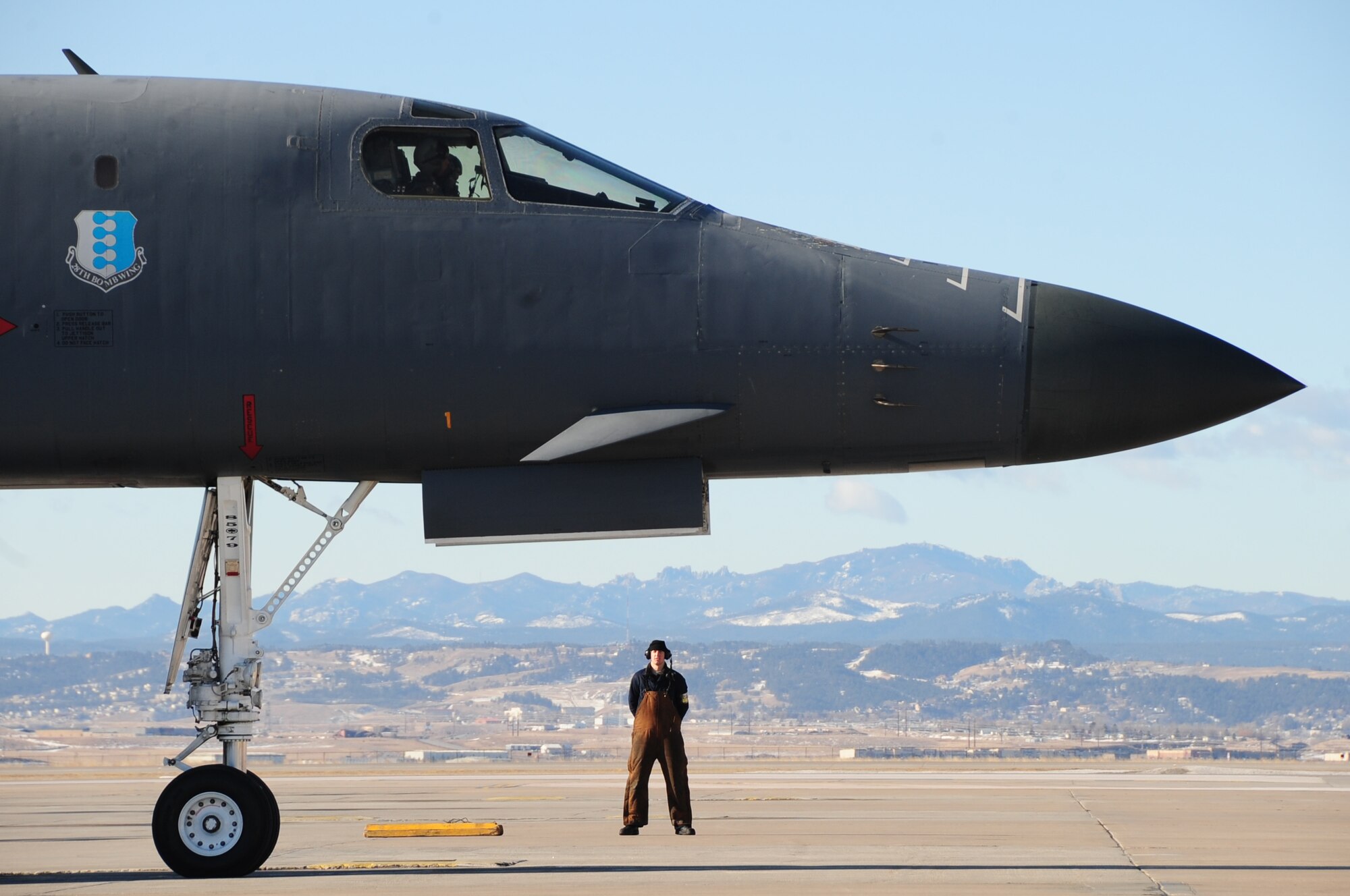 ELLSWORTH AIR FORCE BASE, S.D. -- Airman 1st Class Matthew McFarlan, 37th Bomb Squadron crew chief, stands at parade rest before a B-1B Lance taxis to the runway, Feb. 26.  Col. Kory Cornum, Air Combat Command's command surgeon, flew in the bomber after he visited Ellsworth to recognize top medical performers. (U.S. Air Force photo/Airman 1st Class Anthony Sanchelli)