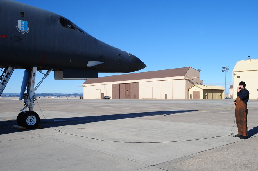 ELLSWORTH AIR FORCE BASE, S.D. -- Airman 1st Class Matthew McFarlan, 37th Bomb Squadron crew chief, talks with pilots as a B-1B Lancer prepares for takeoff, Feb. 26. Col. Kory Cornum, Air Combat Command's command surgeon, flew in the bomber after he visited Ellsworth to recognize top medical performers. (U.S. Air Force photo/Airman 1st Class Anthony Sanchelli)