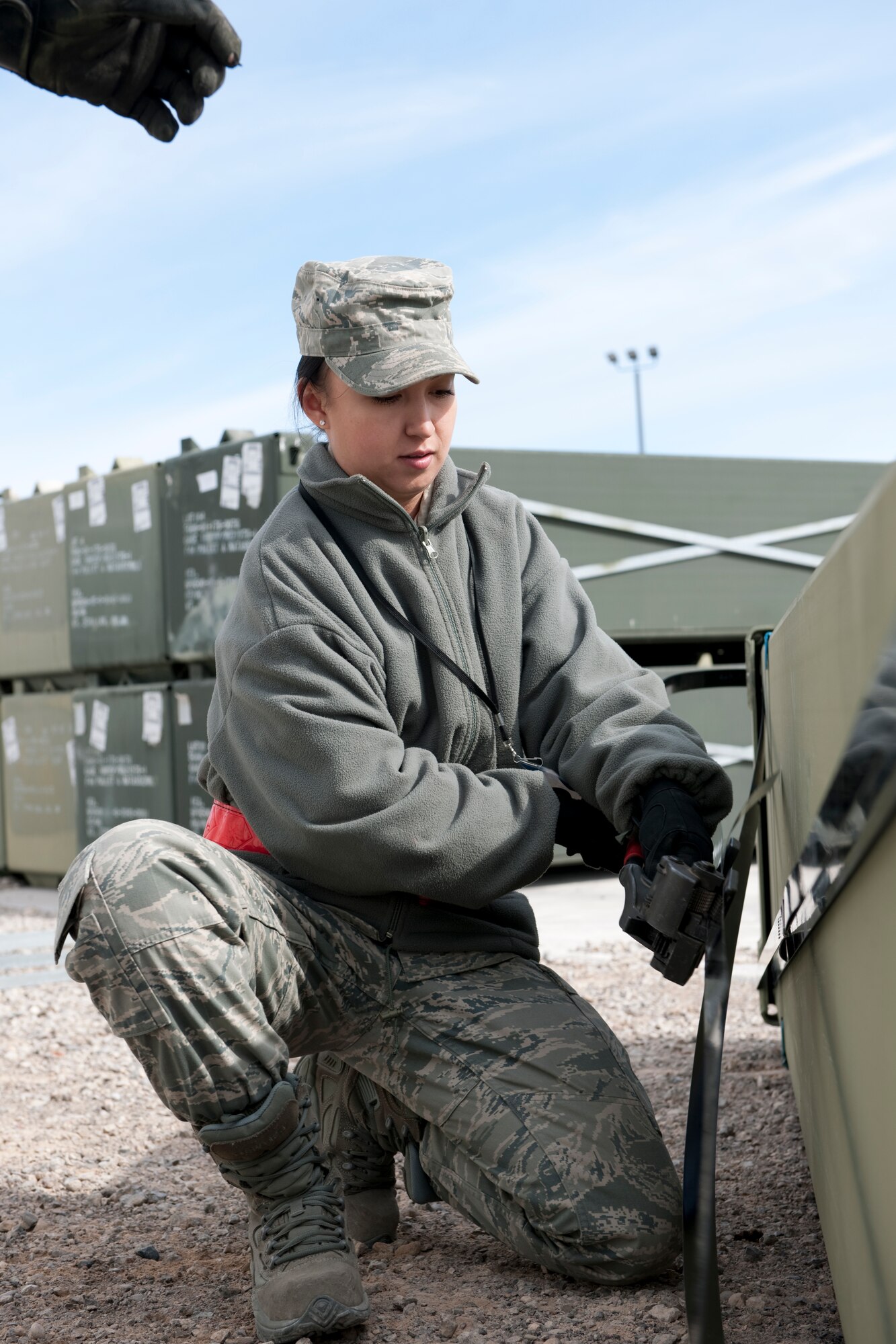 HOLLOMAN, AIR FORCE BASE, N.M. -- Airman 1st Class Olga Apairna, 49th Materiel Maintenance Support Squadron, installs steal straps on a container of AM-2 matting prior to its shipment to Afghanistan on Feb. 24.  The 49th MMSS is deploying 480,000 square-feet of the matting that will be assembled to create airstrips supporting joint and coalition forces throughout Afghanistan. (U.S. Air Force photo by Staff Sgt. Joe Laws) (Released)
