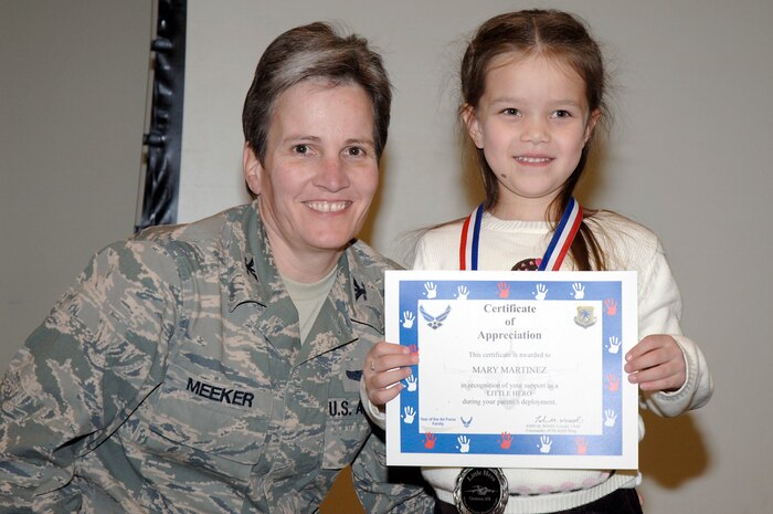 Col. Martha Meeker presents a certificate to Mary Martinez during the Little Heroes ceremony held at the Education and Training Center Feb. 25 at Joint Base Charleston. Little Heroes is a ceremony to recognize children for the sacrifices they made during a parent’s recent deployment. Each child is presented with a medallion with a C-17 imprinted on the face and a certificate signed by the parent’s respective wing commander. Colonel Meeker is the 628th Air Base Wing commander and Mary is the daughter of Staff Sgt. Paul Martinez who is with the 437th Aircraft Maintenance Squadron. (U.S. Air Force photo/Staff Sgt. Marie Brown/Released)