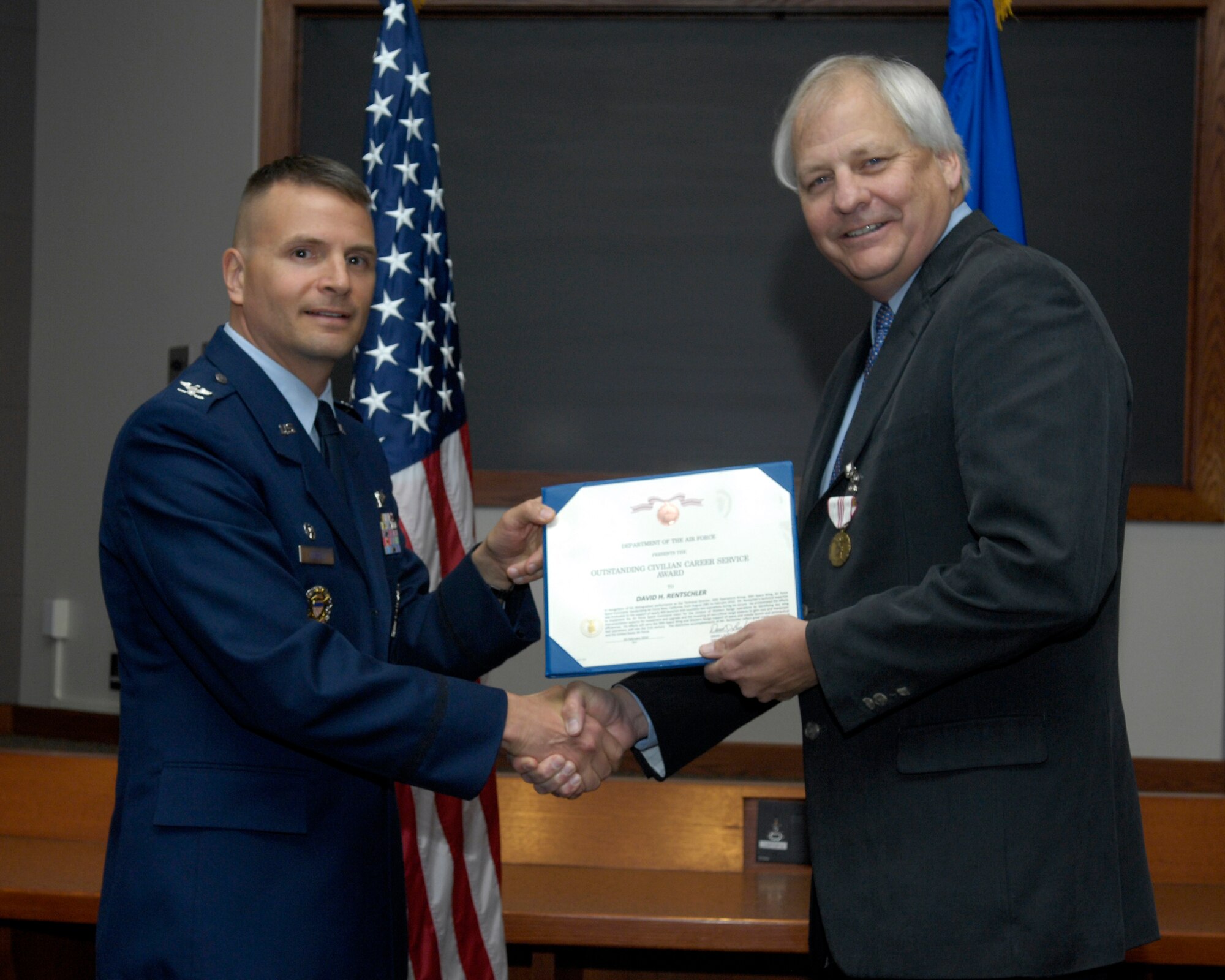 VANDENBERG AIR FORCE BASE, Calif. – Col. Todd Gossett, the 30th Operations Group commander, presents the Outstanding Civilian Career Service Award to David Rentschler, the former 30th OG technical director, during a retirement ceremony here Thursday, Feb. 25, 2010. Mr. Rentschler served 30 years filling many critical roles at Vandenberg. (U.S. Air Force photo/Airman 1st Class Lael Huss)