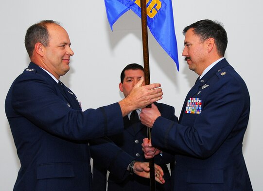 Col. Greg Stroud, 162nd Fighter Wing commander, presents Lt. Col. Eric Kendle, the new 162nd Medical Group commander, the medical group guideon during a change of command ceremony here Feb. 7. (Air Force photo by Master Sgt. Dave Neve)