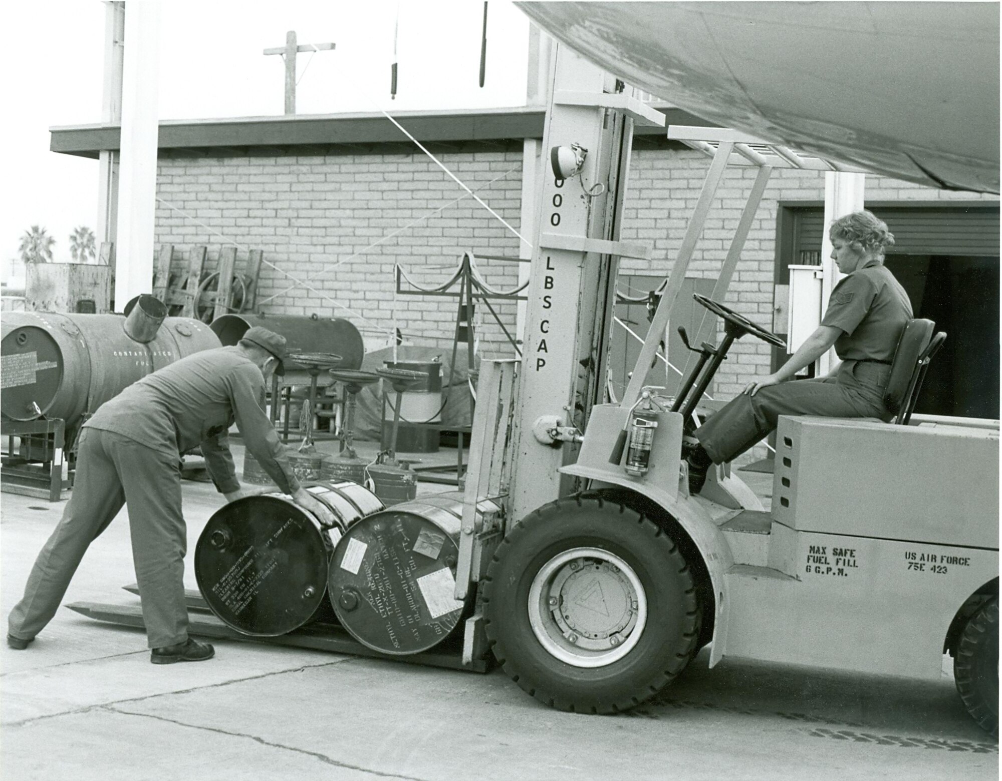 Master Sgt. John “Smitty” Smith, the first enlistee of the 162nd Fighter Wing, helps then Staff Sgt. Brenda West load a fork lift with barrels of methyl ethyl keytone circa 1983. (Courtesy photo)