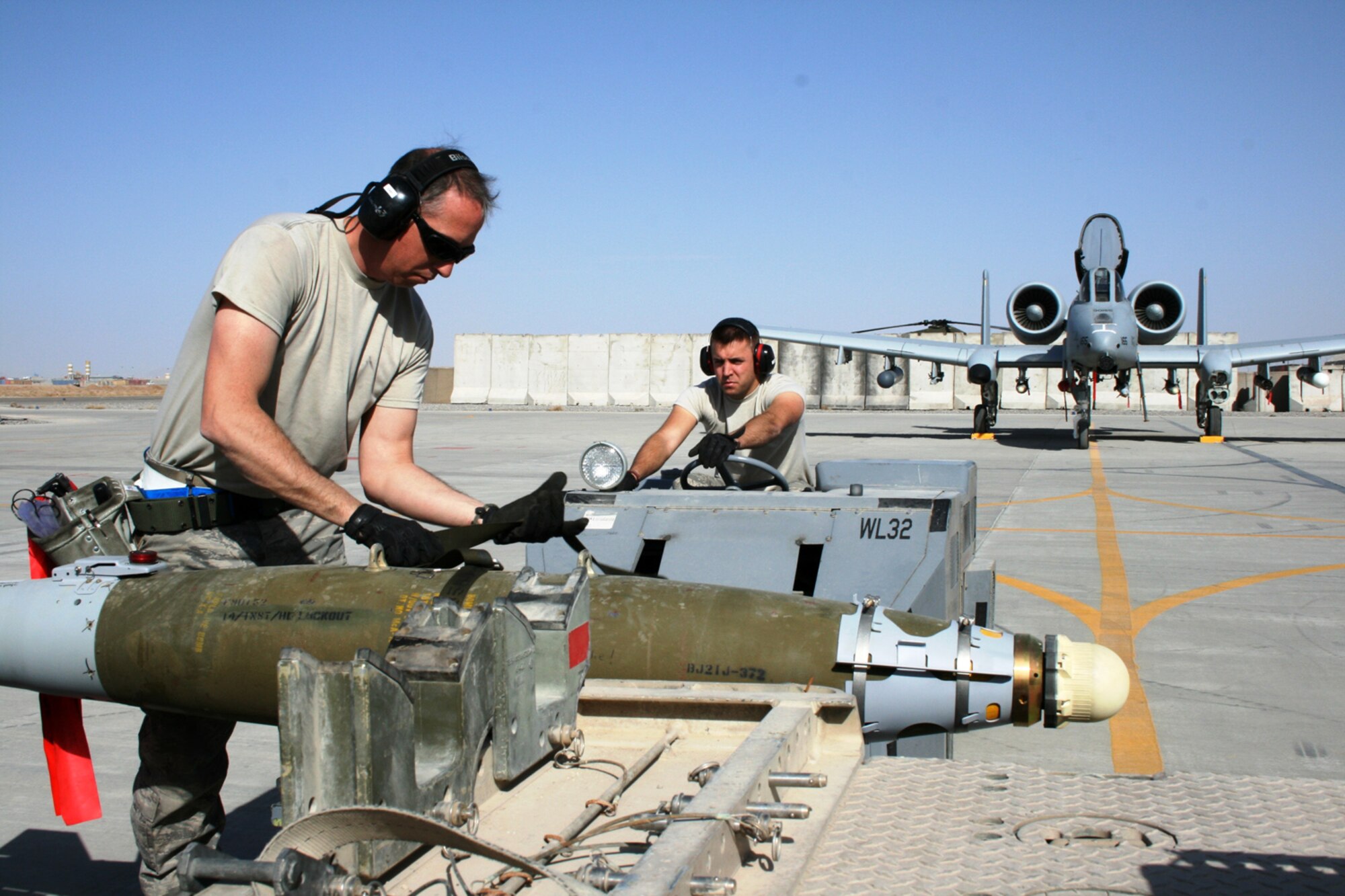 Master Sgt. Craig W. May, left, secures a GBU-38 as Staff Sgt. Charlie Parker waits to drive the bomb over to an A-10C Thunderbolt II "Warthog," Feb. 2, 2010, at Kandahar Airfield in Afghanistan. May and Parker are weapons loaders deployed from the Arkansas Air National Guard's 188th Fighter Wing in Fort Smith, Ark. The 188th deployed approximately 50 Airmen to Afghanistan for a four-month Aerospace Expeditionary Force (AEF) rotation on Jan. 4, 2010. The remainder of the 188th personnel, approximately 250, will begin its portion of the rotation in early March 2010, when the 188th's official rotation begins. (U.S. Air Force photo by Tech. Sgt. David Speicher) 