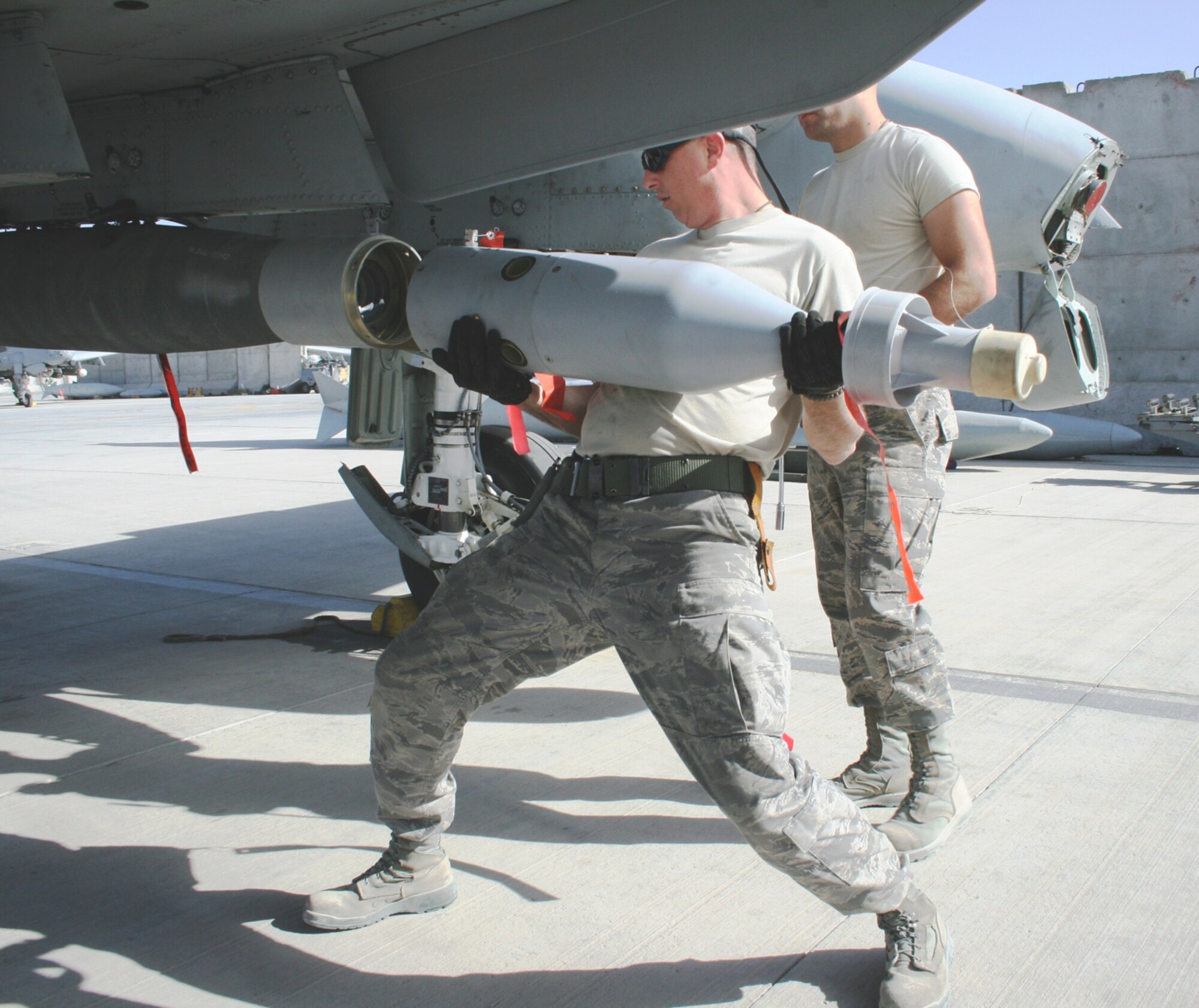Master Sgt. Craig W. May, left, loads a guidance unit to a GBU-12 bomb on an A-10C Thunderbolt II "Warthog," Feb. 2, 2010, at Kandahar Airfield in Afghanistan. May is a weapons loader deployed from the Arkansas Air National Guard's 188th Fighter Wing, based in Fort Smith, Ark. The 188th deployed approximately 50 Airmen to Afghanistan for a four-month Aerospace Expeditionary Force (AEF) rotation on Jan. 4, 2010. The remainder of the 188th personnel, approximately 250, will begin its portion of the rotation in early March 2010, when the 188th's official rotation begins. (U.S. Air Force photo by Tech. Sgt. David Speicher) 