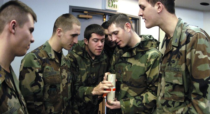 Cadets 1st Class Mark Hammond, Jeff Reddout, Lucas Catalino and Philip Husk examine a dropsonde at the 731st Airlift Squadron at Peterson Air Force Base, Colo., Feb. 9, 2010. The cadets are part of the Spring 2010 Aeronautical Engineering 482 class on aircraft design. A core element of their course is the feasibility of deploying a dropsonde via a remotely piloted aircraft to increase airdrop accuracy. (U.S. Air Force photo/John Van Winkle)