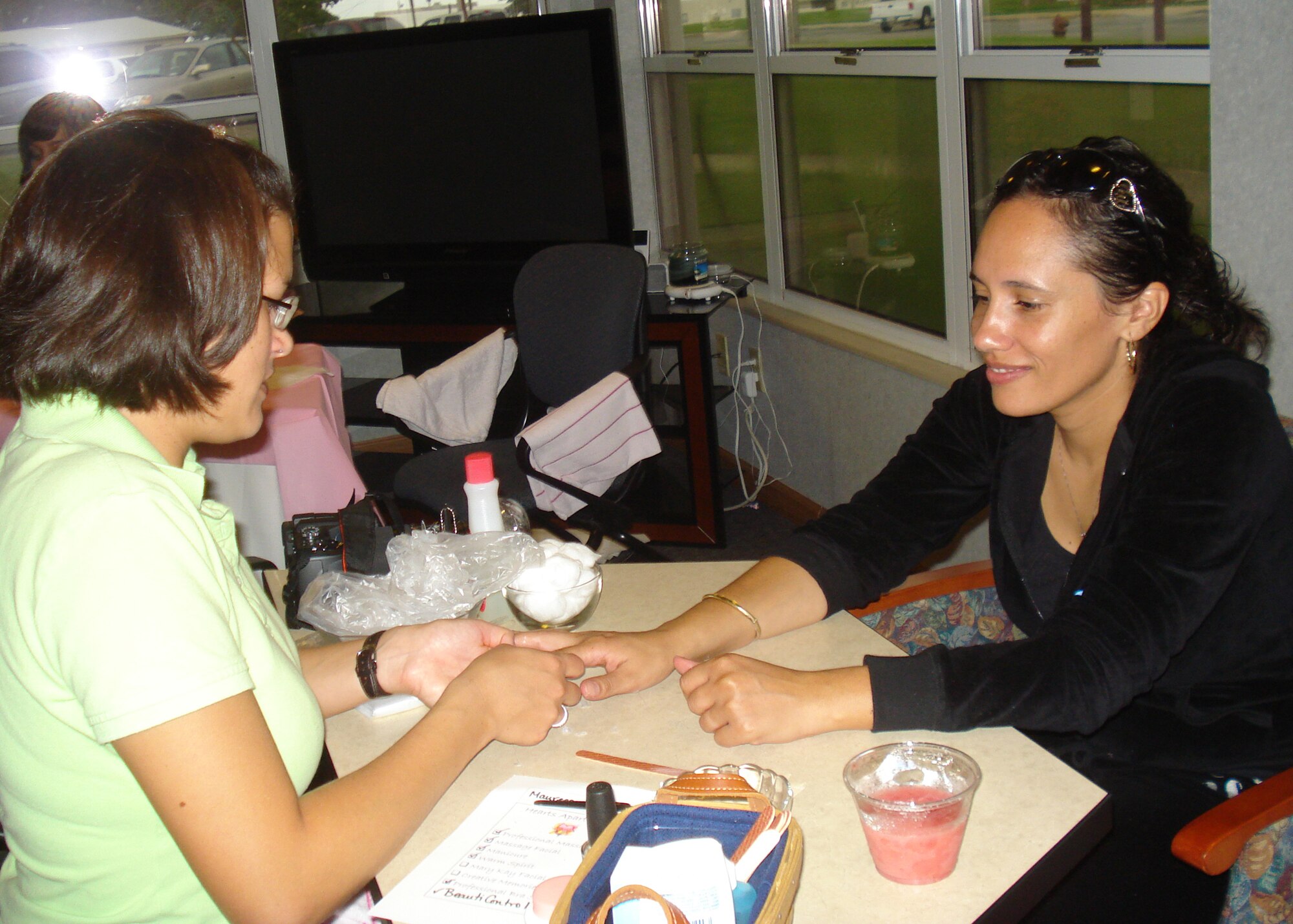 Tech. Sgt. Brooke Matthews (left), from the 96th Force Support Squadron at Randolph Air Force Base, Texas, gives Maureeca Wells a manicure during the Hearts Apart Spa Day, part of a program at Randolph AFB to help provide outreach and services to military, Department of Defense civilians and family members who are, will be or have been separated because of military commitments.  Mrs. Wells' spouse is Tech. Sgt. James Wells, 9th Special Operations Squadron, who is deployed to Iraq.  (Courtesy photo)
