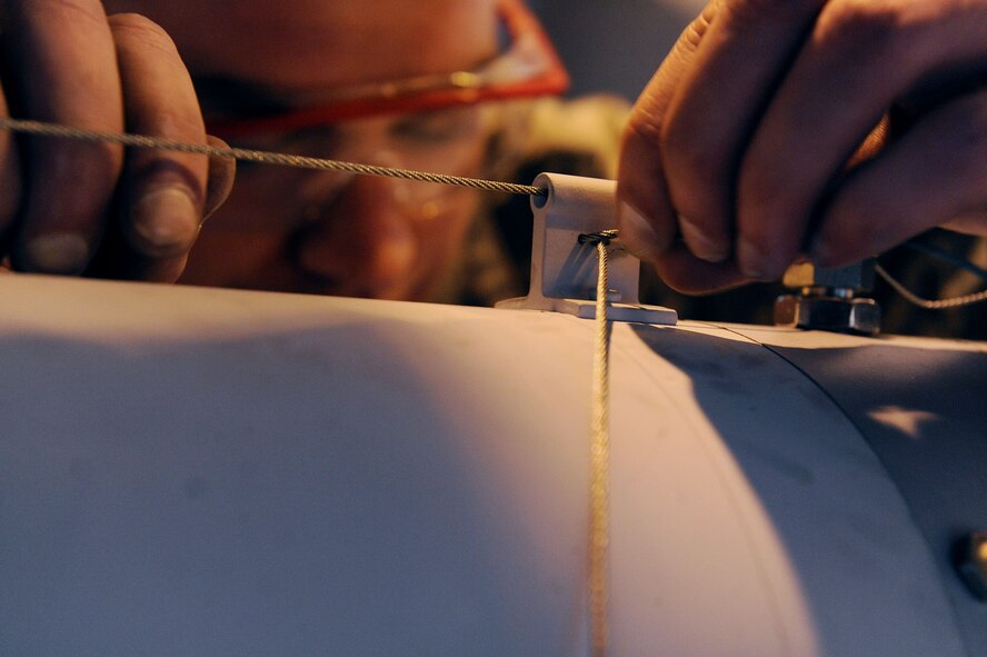 MOODY AIR FORCE BASE Ga. -- Tech. Sgt. Shawn Burchfield, 75th Aircraft Maintenance Unit weapons load crew chief, pushes wires through a hole on an A-10C Thunderbolt II to help hold the missile in place during the 2009 Annual Load Crew Competition here Feb. 12. The competition is a friendly rivalry between the 74th and 75th AMUs. (U.S. Air Force photo by Airman 1st Class Joshua Green)