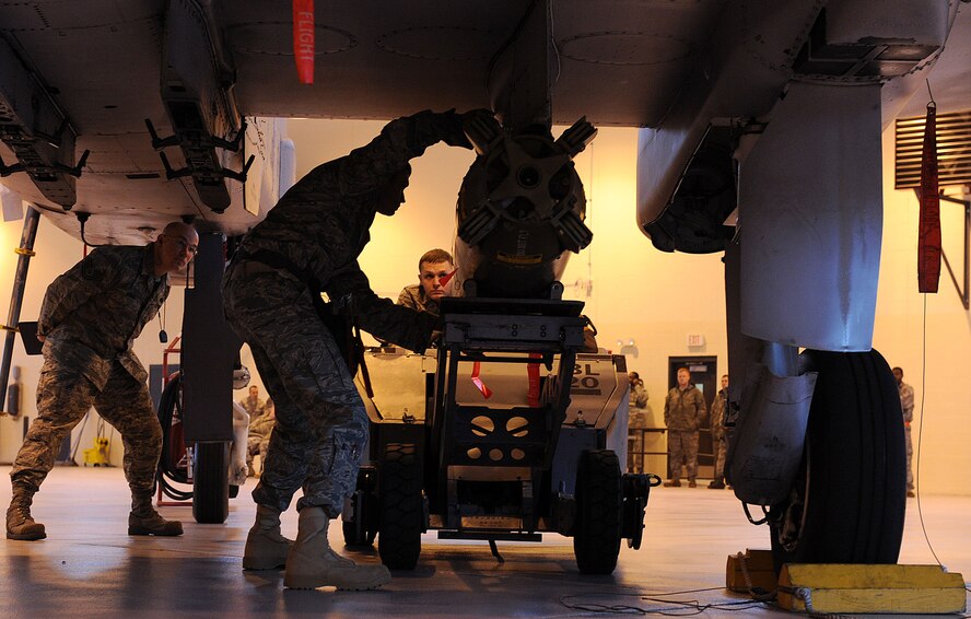 MOODY AIR FORCE BASE Ga. -- Senior Airman Casey Allen, 75th Aircraft Maintenance Unit weapons load crew member, uses a MHU-83 Jammer to lift a cluster bomb into place so Tech Sgt. Shawn Burchfield, 75th AMU weapons load crew chief, can lock it in place during the 2009 Annual Load Crew Competition  here Feb. 12. The competition consisted of three-man teams from the 74th and 75th AMUs who competed to be the best load crew team. (U.S. Air Force photo by Airman 1st Class Joshua Green)