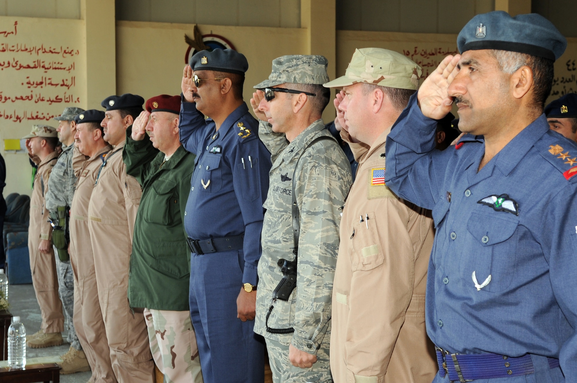 Leaders from the 521st Air Expeditionary Advisory Squadron, 321st Air Expeditionary Advisory Group and Iraqi air force Squadrons 1 and 3 salute both countries' national anthems Jan. 11, 2010, at Kirkuk Air Base, Iraq. (U.S. Air Force photo/Staff Sgt. Tabitha Kuykendall)