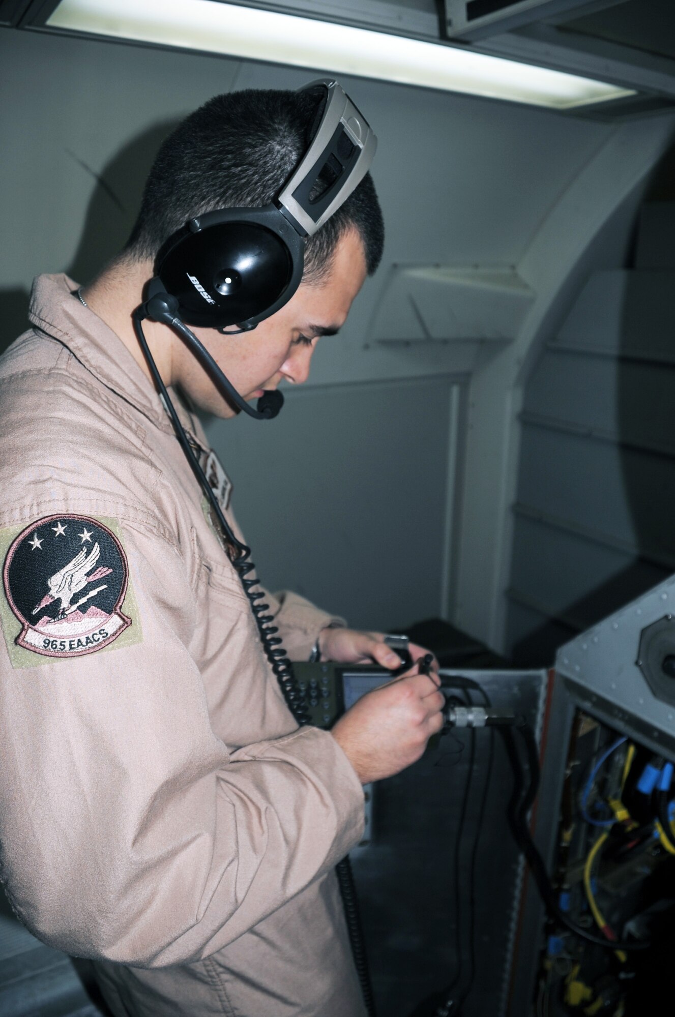 Senior Airman Joshua Slinkard, an E-3 Sentry aircrew member, does a systems check on an E-3 while the plane is in flight for a mission Feb. 16, 2010. Airman Slinkard and the E-3 he's flying on is deployed to a non-disclosed base in Southwest Asia with the 965th Expeditionary Airborne Air Control Squadron. (U.S. Air Force Photo/Master Sgt. Scott T. Sturkol)
