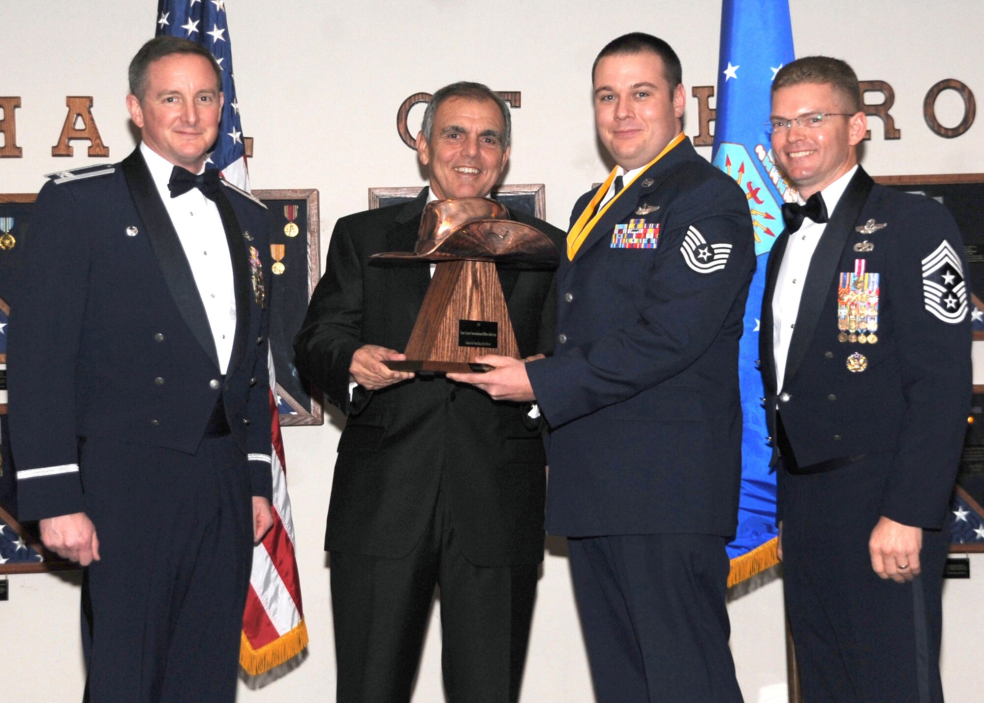 Tech. Sgt Nicholas B. Armitage, 551st Special Operations Squadron, receives the Team Cannon Non-Commissioned Officer of the Year award from (left) Col. Stephen Clark, 27th Special Operations Wing commander, retired Air Force Maj. Gen. Richard Comer, and (right) Chief Master Sgt. William Turner, wing command chief. The wing's top Airmen and civilians were recognized at the annual awards dinner at The Landing Zone at Cannon Air Force Base Feb. 20. (U.S. Air Force photo by Airman 1st Class Maynelinne De La Cruz) 