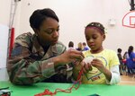 Staff Sgt. Marisha Garris, 543rd Support Squadron, and her daughter Anyla, work on a craft during the African American Heritage Celebration at the youth center Feb. 19. The celebration included games, displays and activities showcasing African American culture. The event was part of a month-long celebration on Lackland honoring the accomplishments and contributions of African Americans to society. (U.S. Air Force photo/Robbin Cresswell)