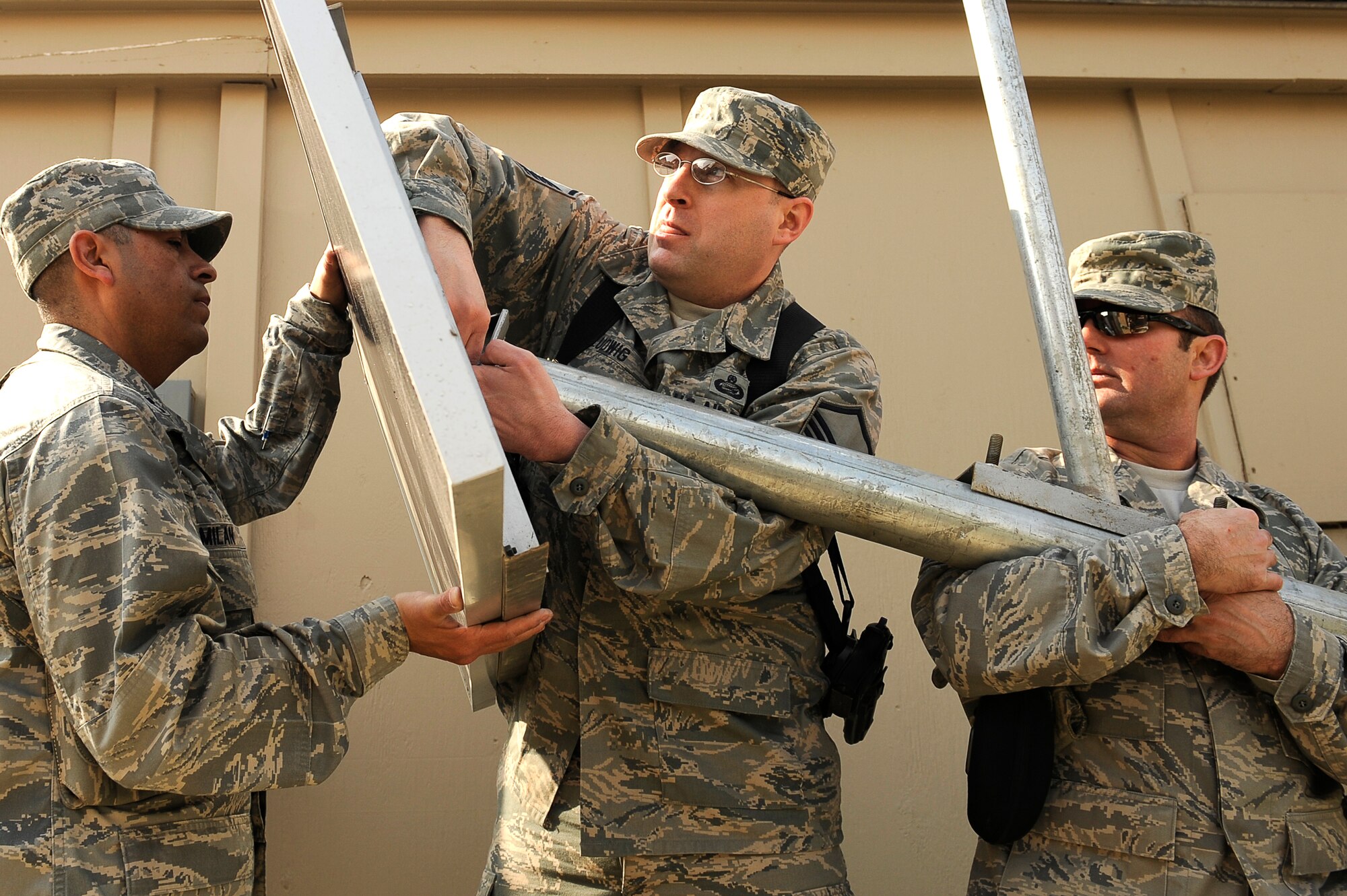 U.S. Air Force Capt. Jose Milan (left), Master Sgt. Todd Ludwig, and Master Sgt. Matthew Trower, 455th Air Expeditionary Wing, Sexual Assault Response Coordinator office, attach the solar panel for a solar powered light being installed at Bagram Airfield, Afghanistan, Feb. 23, 2010. Captain Milan is deployed from Hill Air Force Base, Utah, and is from Navasota, Texas. Sergeant Ludwig is deployed from Scott AFB, Ill., and is from Westland, Mich. Sergeant Trower is deployed from Fairchild AFB, Wash., and is from Liberty Lake, Wash. (U.S. Air Force photo by/ Tech. Sgt. Jeromy K. Cross/released)