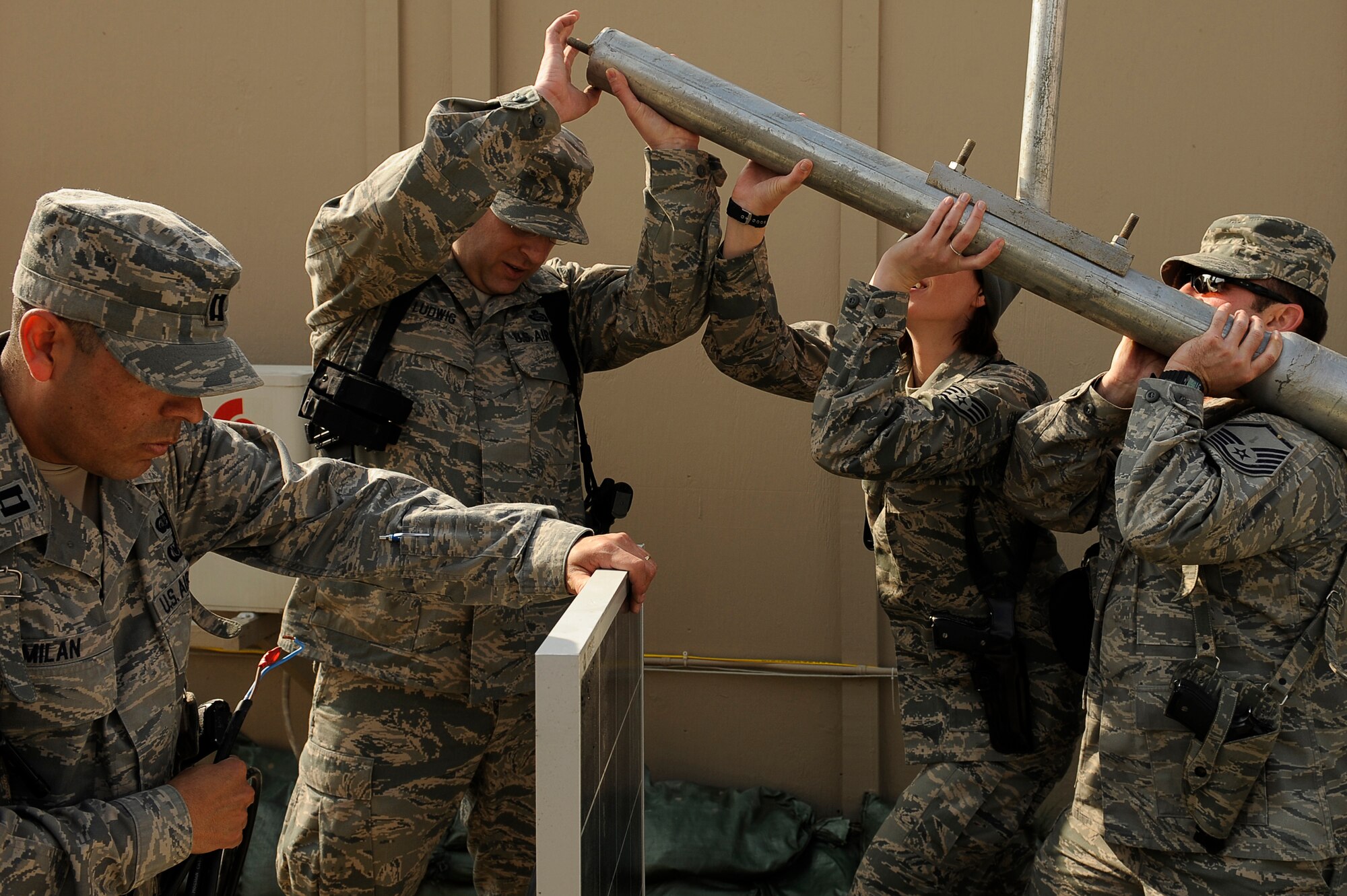 U.S. Air Force Capt. Jose Milan (left), Master Sgt. Todd Ludwig, Staff Sgt. Emily Johanneck, and Master Sgt. Matthew Trower, 455th Air Expeditionary Wing, Sexual Assault Response Coordinator office, raise the pole for a solar powered light being installed at Bagram Airfield, Afghanistan, Feb. 23, 2010. Captain Milan is deployed from Hill Air Force Base, Utah, and is from Navasota, Texas. Sergeant Ludwig is deployed from Scott AFB, Ill., and is from Westland, Mich. Sergeant Johanneck is deployed from Tinker AFB, Okla., and is from Waseca, Minn. Sergeant Trower is deployed from Fairchild AFB, Wash., and is from Liberty Lake, Wash. (U.S. Air Force photo by/ Tech. Sgt. Jeromy K. Cross/released)