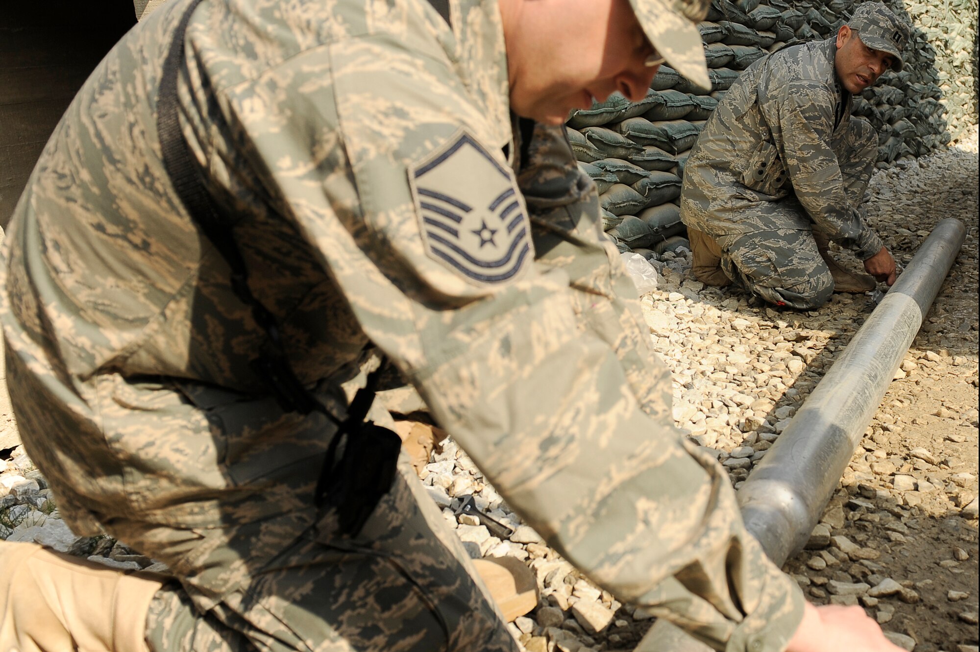 U.S. Air Force Capt. Jose Milan (right), and Master Sgt. Todd Ludwig, 455th Air Expeditionary Wing, Sexual Assault Response Coordinator office, run the wiring for a solar powered light being installed at Bagram Airfield, Afghanistan, Feb. 23, 2010. Captain Milan is deployed from Hill Air Force Base, Utah, and is from Navasota, Texas. Sergeant Ludwig is deployed from Scott AFB, Ill., and is from Westland, Mich. (U.S. Air Force photo by/ Tech. Sgt. Jeromy K. Cross/released)
