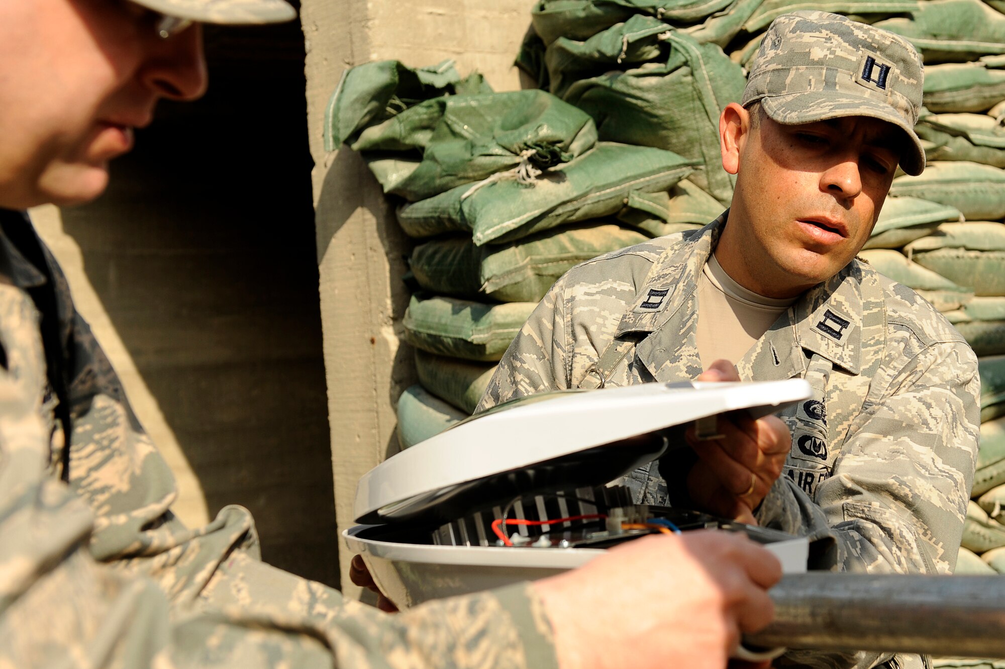 U.S. Air Force Capt. Jose Milan (right), and Master Sgt. Todd Ludwig, 455th Air Expeditionary Wing, Sexual Assault Response Coordinator office, connect the light head for a solar powered light being installed at Bagram Airfield, Afghanistan, Feb. 23, 2010. Captain Milan is deployed from Hill Air Force Base, Utah, and is from Navasota, Texas. Sergeant Ludwig is deployed from Scott Air Force Base, Ill., and is from Westland, Mich. (U.S. Air Force photo by/ Tech. Sgt. Jeromy K. Cross/released)