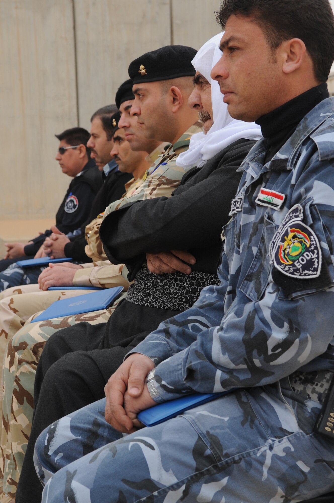 Members of the 506th Civil Engineer Squadron Explosive Ordnance Disposal team, memorialize three Iraqi Police Counter-explosive team members killed by a vehicle-borne IED on 12 August of last year by unveiling a mural painted in their honor at the EOD compound on Kirkuk Regional Air Base Feb. 23, 2010. The families of the fallen were presented donated funds raised during an EOD bomb suit run.  (U.S. Air Force photo/Staff Sgt. Tabitha Kuykendall/Released)