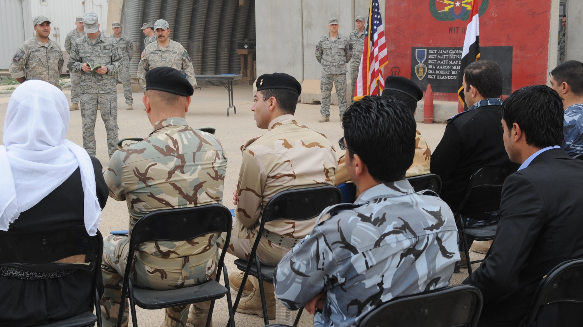 Members of the 506th Civil Engineer Squadron Explosive Ordnance Disposal team, memorialize three Iraqi Police Counter-explosive team members killed by a vehicle-borne IED on 12 August of last year by unveiling a mural painted in their honor at the EOD compound on Kirkuk Regional Air Base Feb. 23, 2010. The families of the fallen were presented donated funds raised during an EOD bomb suit run.  (U.S. Air Force photo/Staff Sgt. Tabitha Kuykendall/Released)