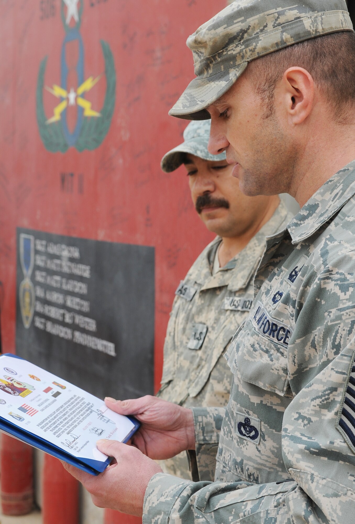 Members of the 506th Civil Engineer Squadron Explosive Ordnance Disposal team, memorialize three Iraqi Police Counter-explosive team members killed by a vehicle-borne IED on 12 August of last year by unveiling a mural painted in their honor at the EOD compound on Kirkuk Regional Air Base Feb. 23, 2010. The families of the fallen were presented donated funds raised during an EOD bomb suit run.  (U.S. Air Force photo/Staff Sgt. Tabitha Kuykendall/Released)