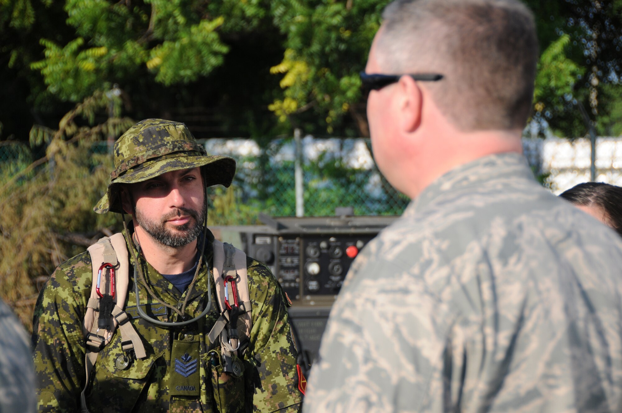 Lt. Col David Mounkes, the Global Mobility Squadron Commander from the Kentucky Air National Guard?s 123rd Contingency Response Group, talks with Sgt. Eric Thompkin from the Canadian Air Force at an air hub at Barahona, Dominican Republic, Jan. 24. The Kentucky Guardsmen established the hub Jan. 22 to process inbound humanitarian aid for victims of the earthquake in Haiti. (U.S. Air Force photo by Tech. Sgt. Dennis Flora)