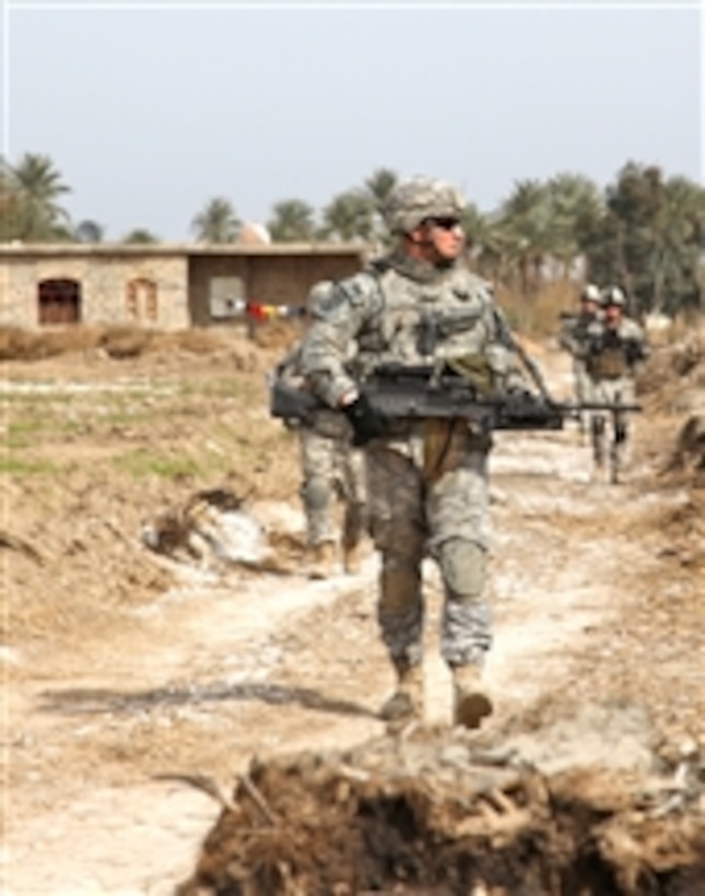 U.S. Army Pfc. Justin Gallager, assigned to Alpha Company, 1st Battalion, 38th Infantry Regiment, 4th Brigade, 2nd Infantry Division, carries an M240B machine gun on a patrol near Baghdad, Iraq, on Feb. 11, 2010.  