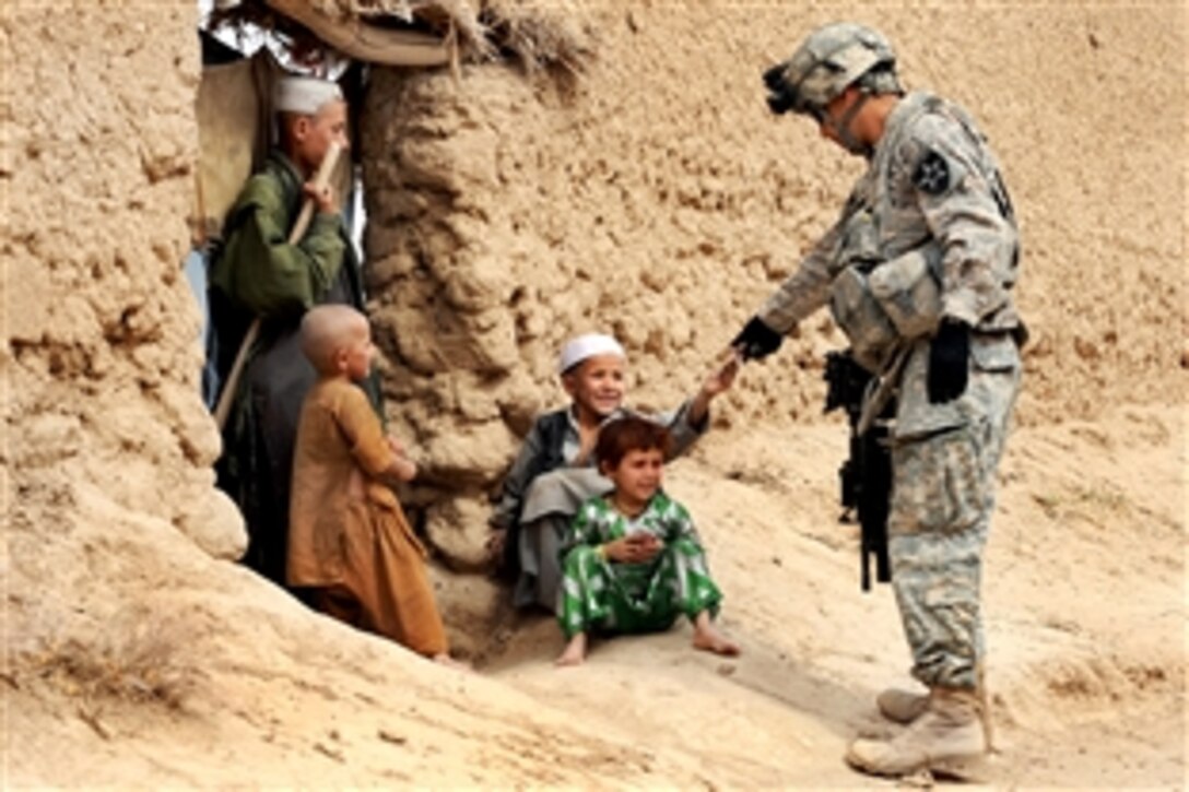 U.S. Army Sgt. Jose Gonzalez gives snacks to Afghan children during a patrol in Dagyan village in Helmand province, Afghanistan, Feb. 21, 2010. Gonzalez is assigned to Company C, 4th Battalion, 23rd Infantry Regiment.