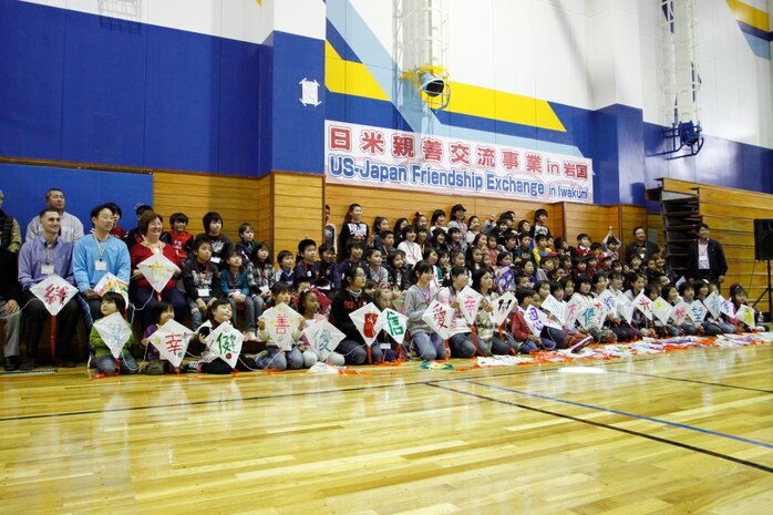 Matthew C. Perry Elementary and Kawashimo Elementary School students, among other participants including the mayor of Iwakuni, pose for a group photo after decorating kites at the U.S.–Japan Friendship Exchange at the IronWorks Gym here Feb. 27. The event was organized by the Chugoku-Shikoku Defense Bureau and co–sponsored by Marine Corps Air Station Iwakuni and Iwakuni city.