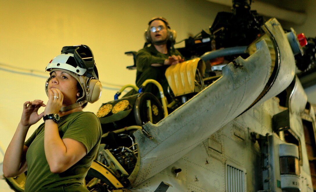 Cpl. Kristina Sims, a maintenance administrator with Marine Medium Helicopter Squadron 265 Reinforced (HMM-265 REIN), 31st Marine Expeditionary Unit (MEU), calls for a crane while Sgt. Michael Zandaki, a phase crew quality assurance technician with HMM-265 REIN, 31st MEU, inspects a CH-46 Sea Knight Helicopter’s flight control unit during scheduled maintenance aboard the forward deployed amphibious assault ship USS Essex (LHD-2), Feb. 27. The MEU recently completed Exercise Cobra Gold 2010 (CG ’10) and is currently scheduled to go underway to the Republic of the Philippines in support of Exercise Balikatan 2010 (BK ’10).