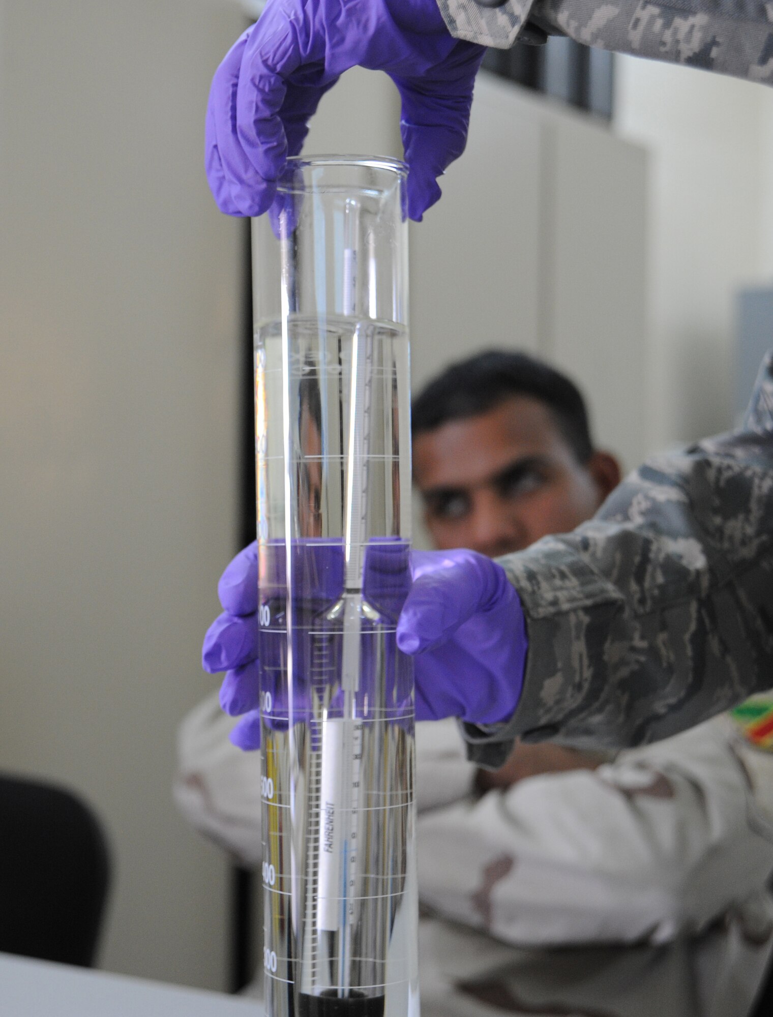 U.S. Air Force Tech. Sgt. Kathleen Franklin, 821st Expeditionary Training Squadron petroleum oil & lubrication class advisor, demonstrates to a class of Iraqi students how to measure different types of gas using a cylinder and a hydrometer during class at Camp Taji, Iraq, Feb. 13, 2010. This POL class is advised by U.S. Air Force personnel who teach the Iraqi military how to be self sufficient in protecting their equipment and personnel while checking fuel for contaminants that can be potentially hazardous. (U.S. Air Force photo/Master Sgt. Trish Bunting/Released)