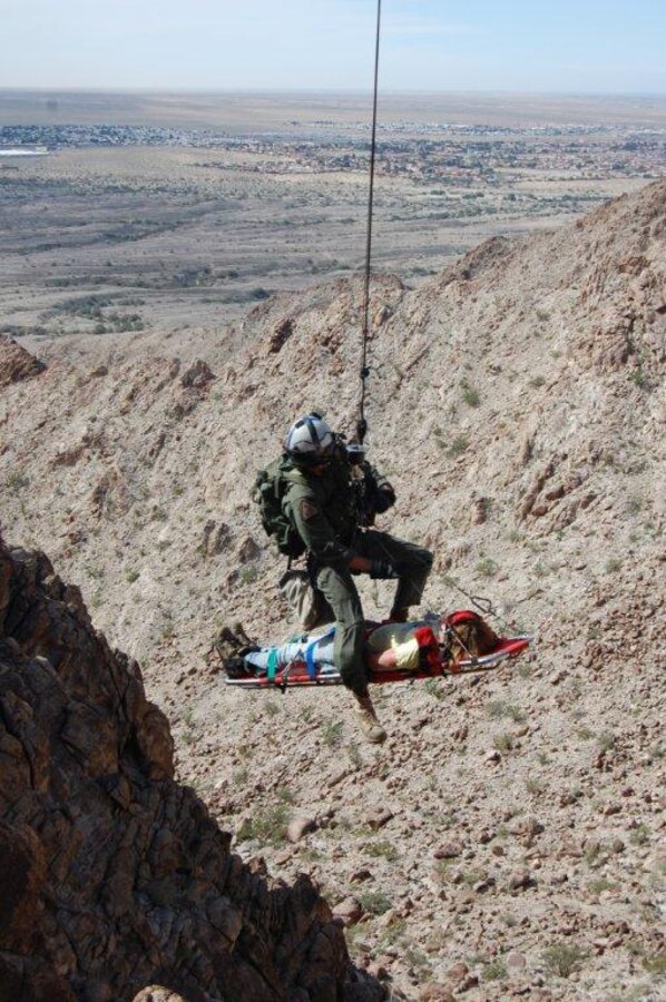 Petty Officer 3rd Class Charles White, Search and Rescue corpsman, stabilizes 17-year-old Bobby Brown, a Yuma, Ariz., resident, on a litter as he is airlifted from his accident in the Gila Mountains of Arizona Feb. 27, 2010. During a hike, Brown fell breaking the joint of his right thumb and severing nerves in his right hand.