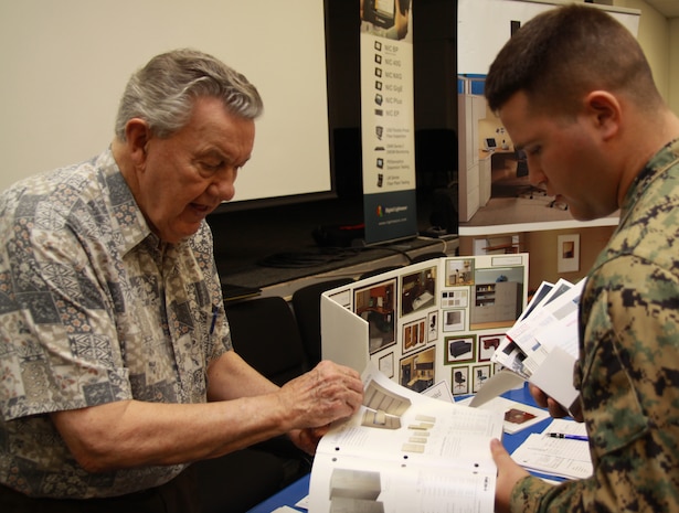 Joseph E. Johnson, Integrated Interiors International president / CEO, shows Sgt. Wesley Cary, an ammunition technician with Headquarters and Service Battalion, U.S. Marine Corps Forces, Pacific, a filing cabinet catalogue March 1 at MarForPac, Camp H. M. Smith, Hawaii during the 2010 Technology and Industry Day. Officials with U.S. Pacific Command's Joint Communications Section host the annual event to introduce service members to new technologies that may enhance military operations, whether deployed or in garrison.