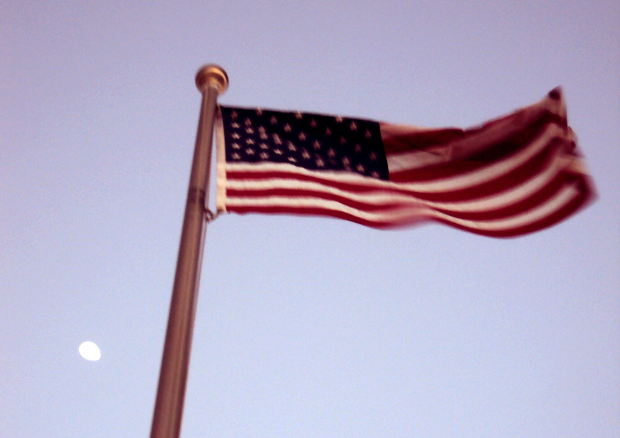 The American flag flying in front of the 380th Air Expeditionary Wing headquarters is backdropped by the rising moon at a non-disclosed base in Southwest Asia on Feb. 24, 2010. (U.S. Air Force Photo/Master Sgt. Scott T. Sturkol/Released)