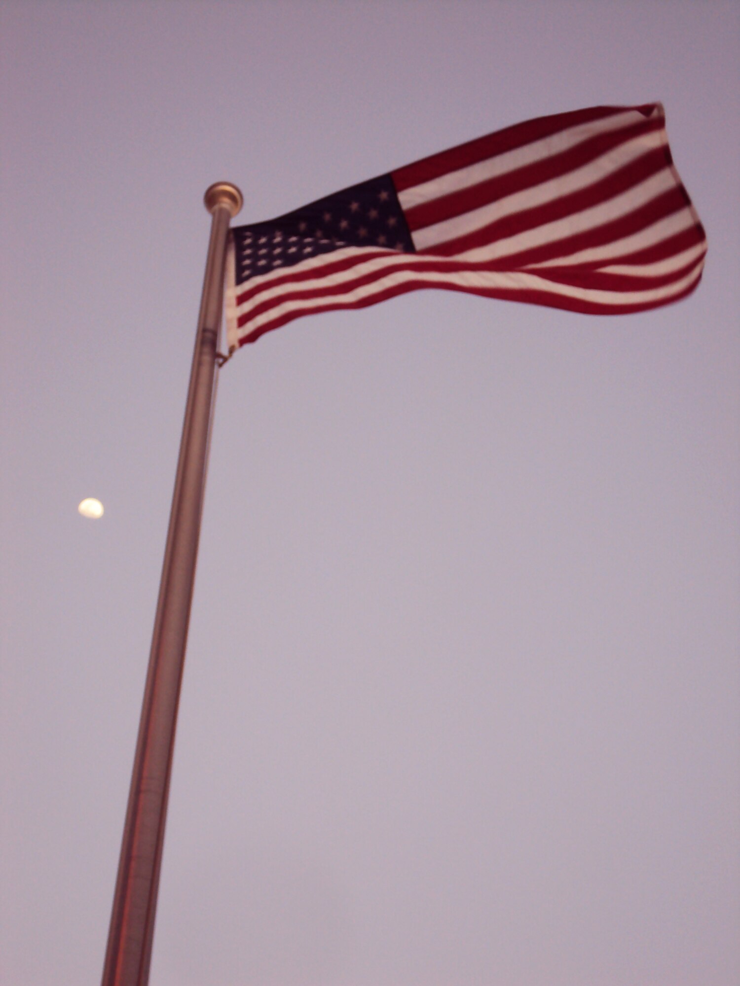 The American flag flying in front of the 380th Air Expeditionary Wing headquarters is backdropped by the rising moon at a non-disclosed base in Southwest Asia on Feb. 24, 2010. (U.S. Air Force Photo/Master Sgt. Scott T. Sturkol/Released)