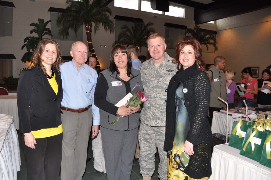 Jackie Newman (center) wife of Col. Brett Newman, receives the Military Spouse of the Year award, including a gift from New Beginnings spa, at the 934th Yellow Ribbon event Jan. 23. From left are Tiffany Sudbeck, the spa?s customer service manager, Col. Vic Seaver, E.W. Rawlings Air Force Association president, Col. Ron Wilt, 934th Operations Group commander, and Melissa Sanchelli-Gabriel, the spa owner. (Air Force Photo/Capt. S.J. Brown)