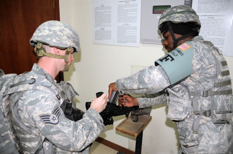 Staff Sgt. James Dees has his M-4 rifle inspected and ready for loading by Tech. Sgt. Andre Scott, both are with the 380th Expeditionary Security Forces Squadron, while both wear their protective armor during a security forces training exercise Feb. 20, 2010, at a non-disclosed base in Southwest Asia.  Sergeant Dees is deployed from the 87th Security Forces Squadron at Joint Base McGuire-Dix-Lakehurst, N.J. Sergeant Scott is deployed from the 436th SFS at Dover AFB, Del. The 380th ESFS, as part of the 380th Air Expeditionary Wing, supports operations Iraqi Freedom and Enduring Freedom and the Combined Joint Task Force-Horn of Africa. (U.S. Air Force Photo/Master Sgt. Scott T. Sturkol/Released)