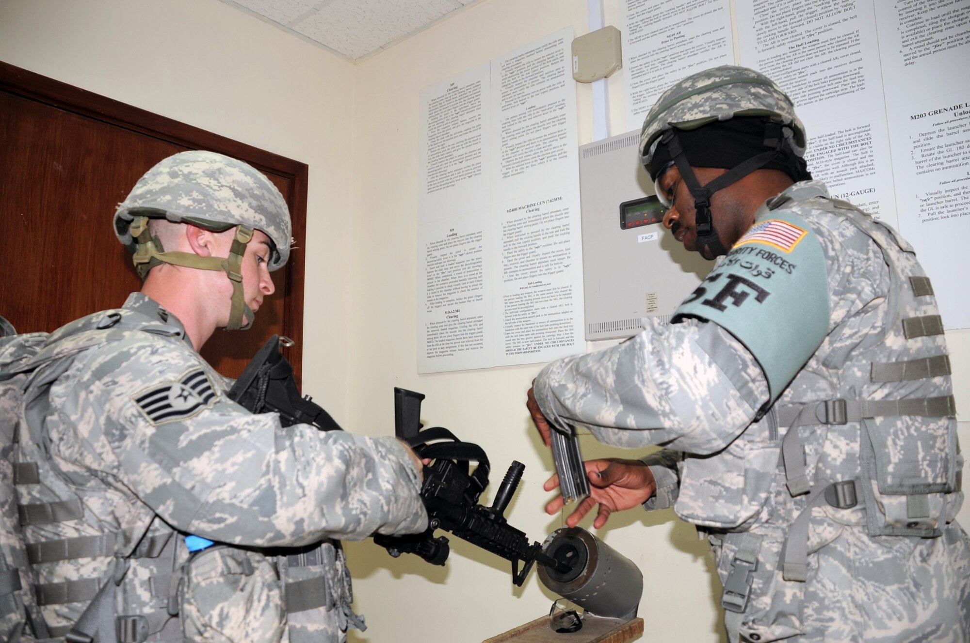 Staff Sgt. James Dees has his M-4 rifle inspected and ready for loading by Tech. Sgt. Andre Scott, both are with the 380th Expeditionary Security Forces Squadron, while both wear their protective armor during a security forces training exercise Feb. 20, 2010, at a non-disclosed base in Southwest Asia.  Sergeant Dees is deployed from the 87th Security Forces Squadron at Joint Base McGuire-Dix-Lakehurst, N.J. Sergeant Scott is deployed from the 436th SFS at Dover AFB, Del. The 380th ESFS, as part of the 380th Air Expeditionary Wing, supports operations Iraqi Freedom and Enduring Freedom and the Combined Joint Task Force-Horn of Africa. (U.S. Air Force Photo/Master Sgt. Scott T. Sturkol/Released)