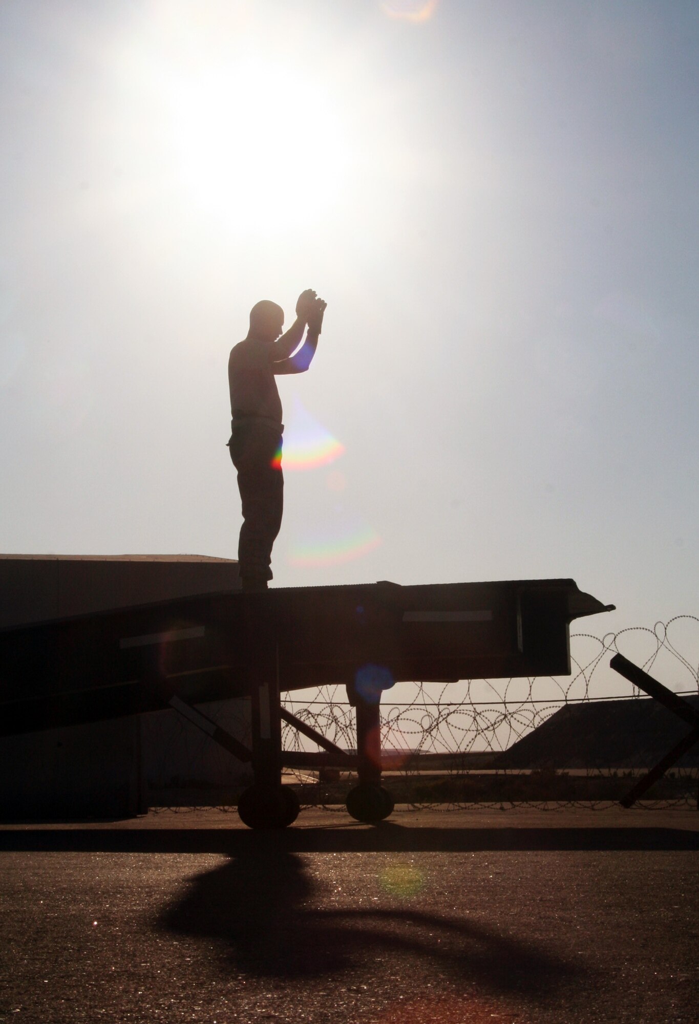 Tech. Sgt. Andrew McMahon, noncommissioned officer-in-charge of the 380th Expeditionary Logistics Readiness Squadron Air Terminal Operations Center, directs the loading of a 20,000-pound bus on a loader during operations at a non-disclosed location in Southwest Asia on Dec. 30, 2009.  Sergeant McMahon and five other air transportation Airmen loaded two buses on a Russian-built IL-76 transport which flew the buses to Afghanistan. Sergeant McMahon is deployed from the 89th Aerial Port Squadron at Andrews Air Force Base, Md., and his hometown is Van Wert, Ohio. (U.S. Air Force Photo/Tech. Sgt. Scott T. Sturkol)