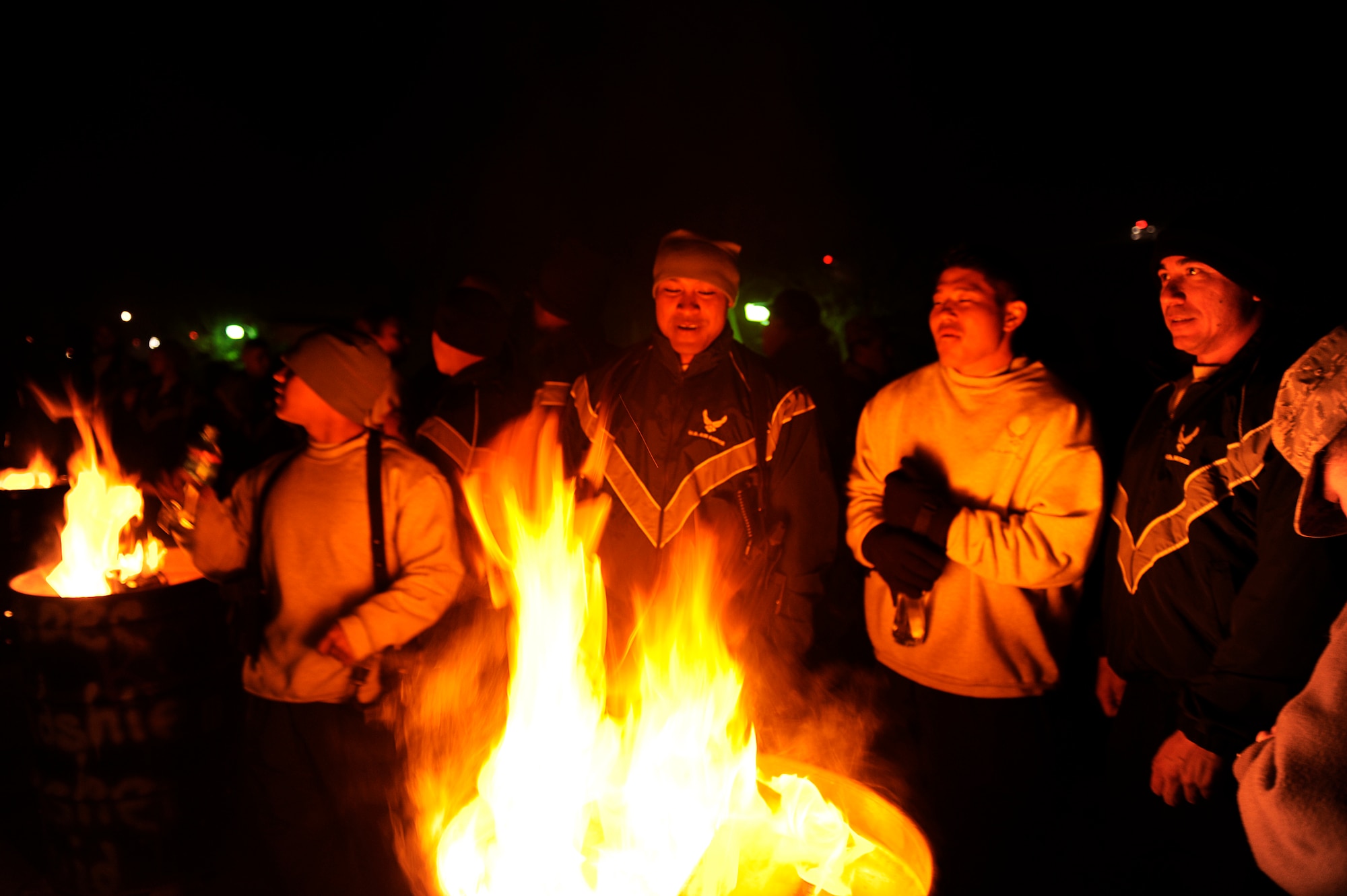 BAGRAM AIRFIELD, Afghanistan--Airmen at Bagram Airfield warm up next to a fire while waiting to celebrate the New Year Dec. 31, 2009. (U.S. Air Force photo by: Tech. Sgt. Jeromy K. Cross)